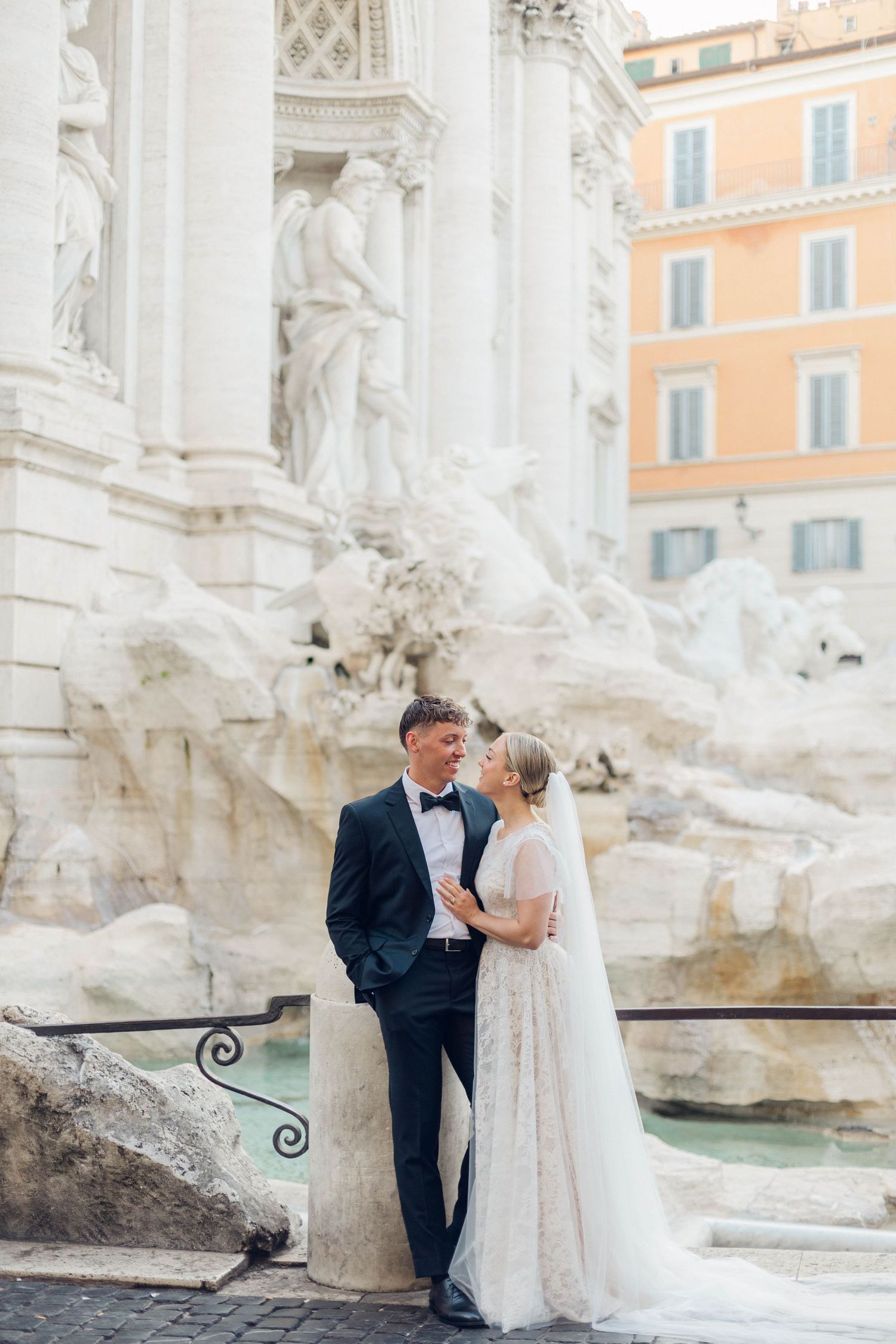 Elegant first look at the Trevi Fountain with baroque sculptures and historic architecture in the background.