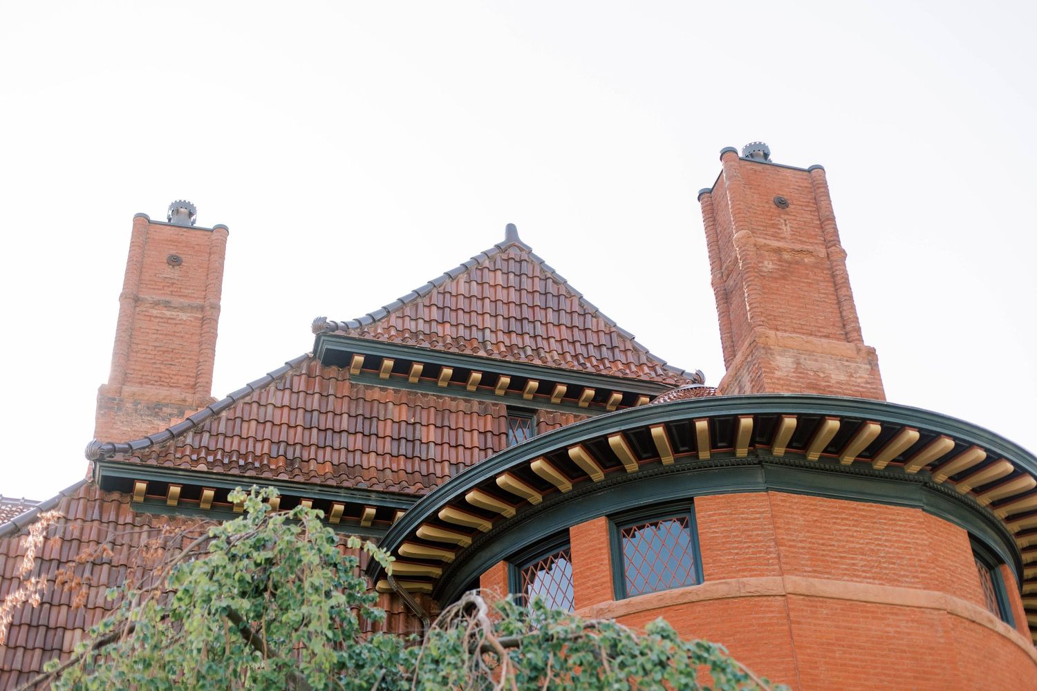 Historic red brick building with unique architectural details and pyramidal roof design.
