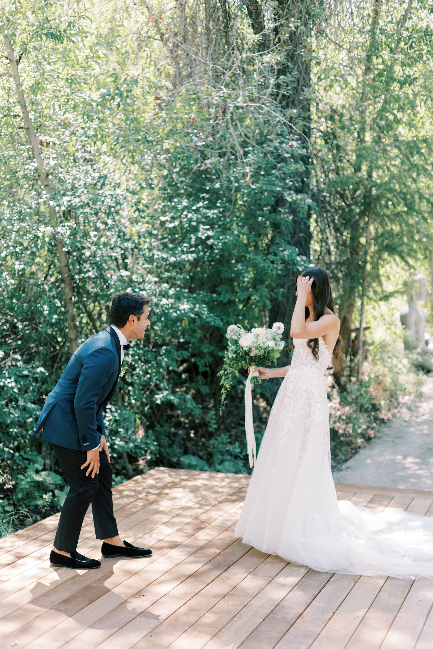 Wedding couple sharing their first look moment on an outdoor wooden deck at blue sky ranch.