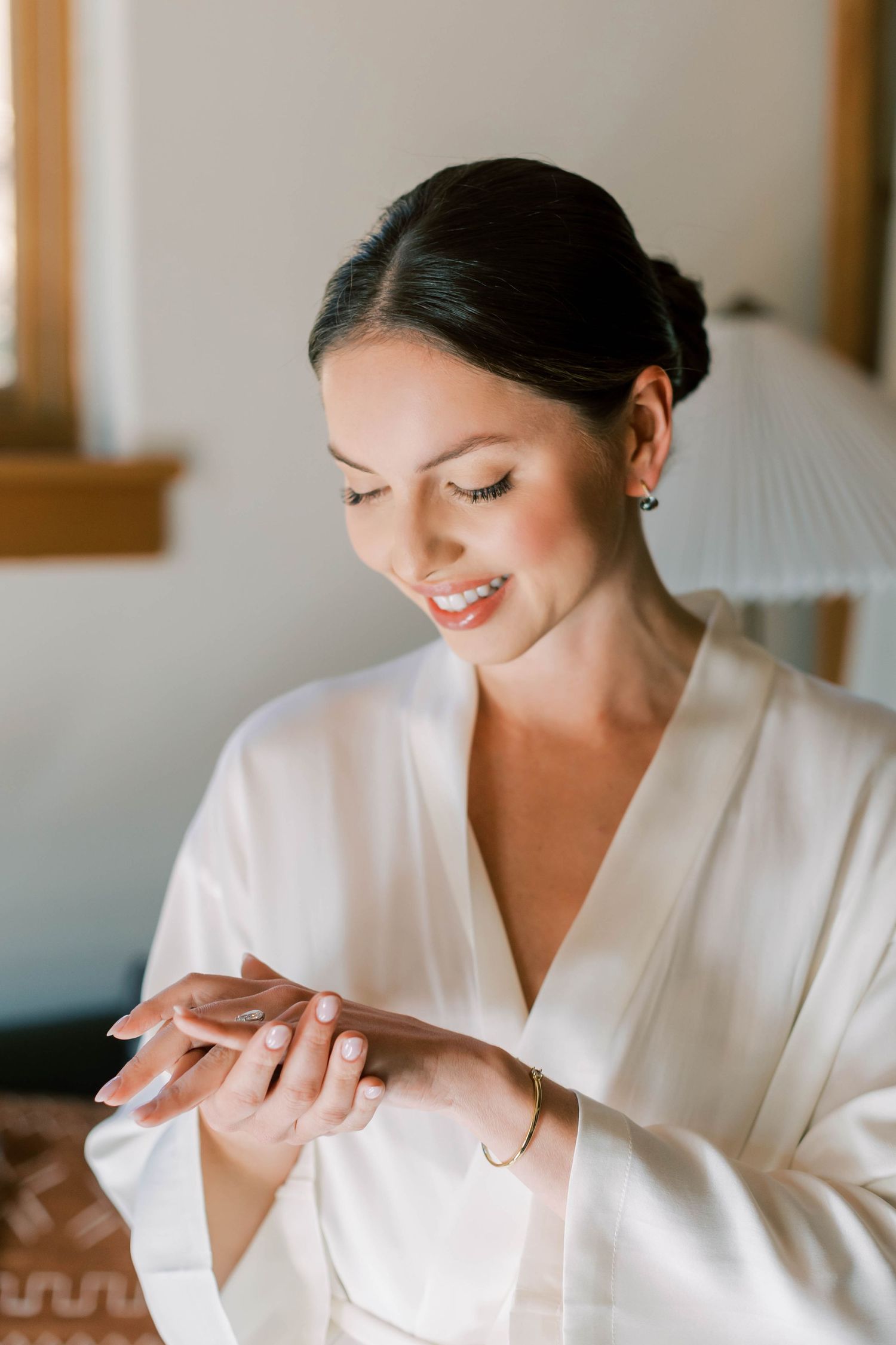 A person in a white silk robe with elegant makeup and hair styling.
