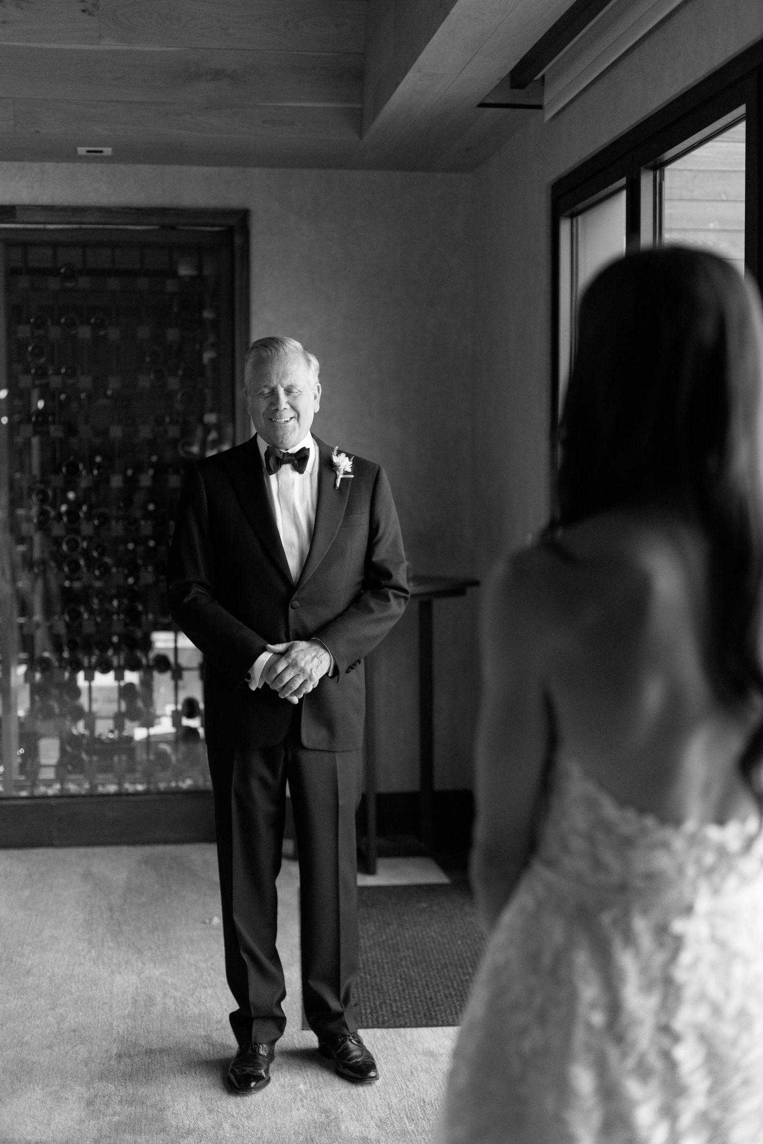 Emotional first look moment between a suited man and bride in an elegant indoor setting.