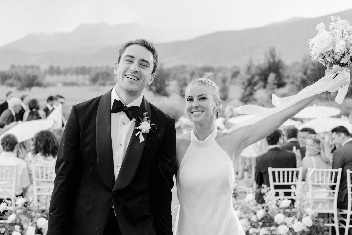 Joyful newlyweds celebrating during recessional at outdoor mountain venue.