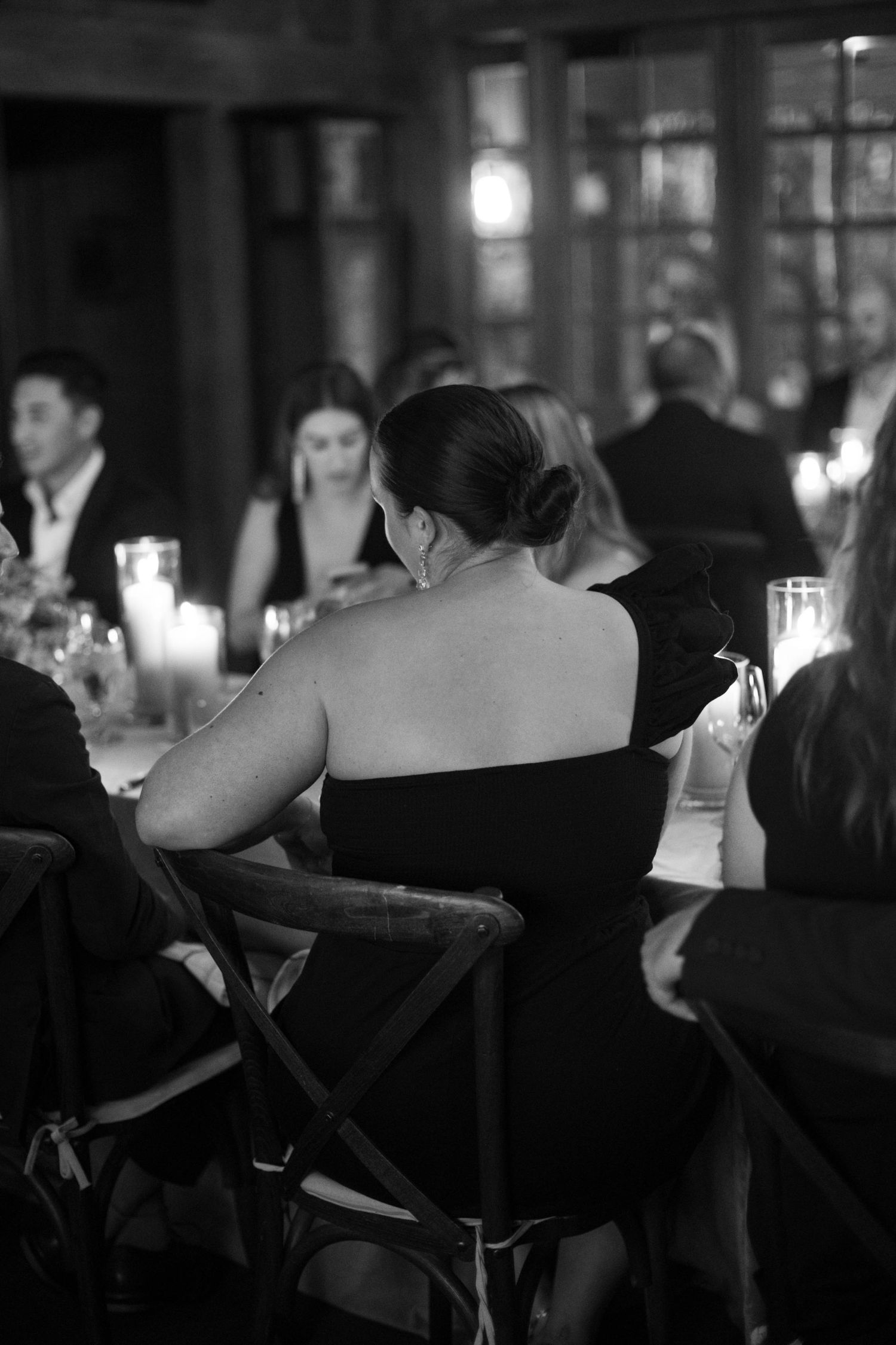 Guests seated at an elegant candlelit dinner in formal attire.