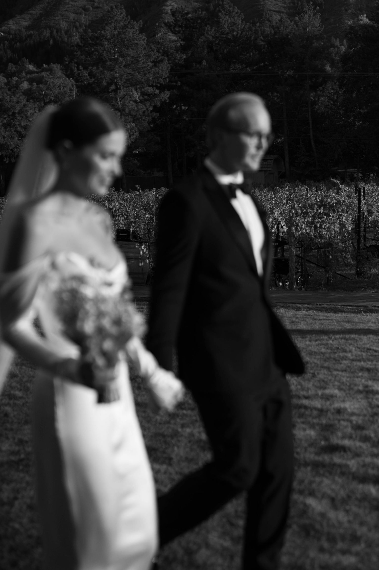 An artistic black and white wedding photo captured in a garden setting.