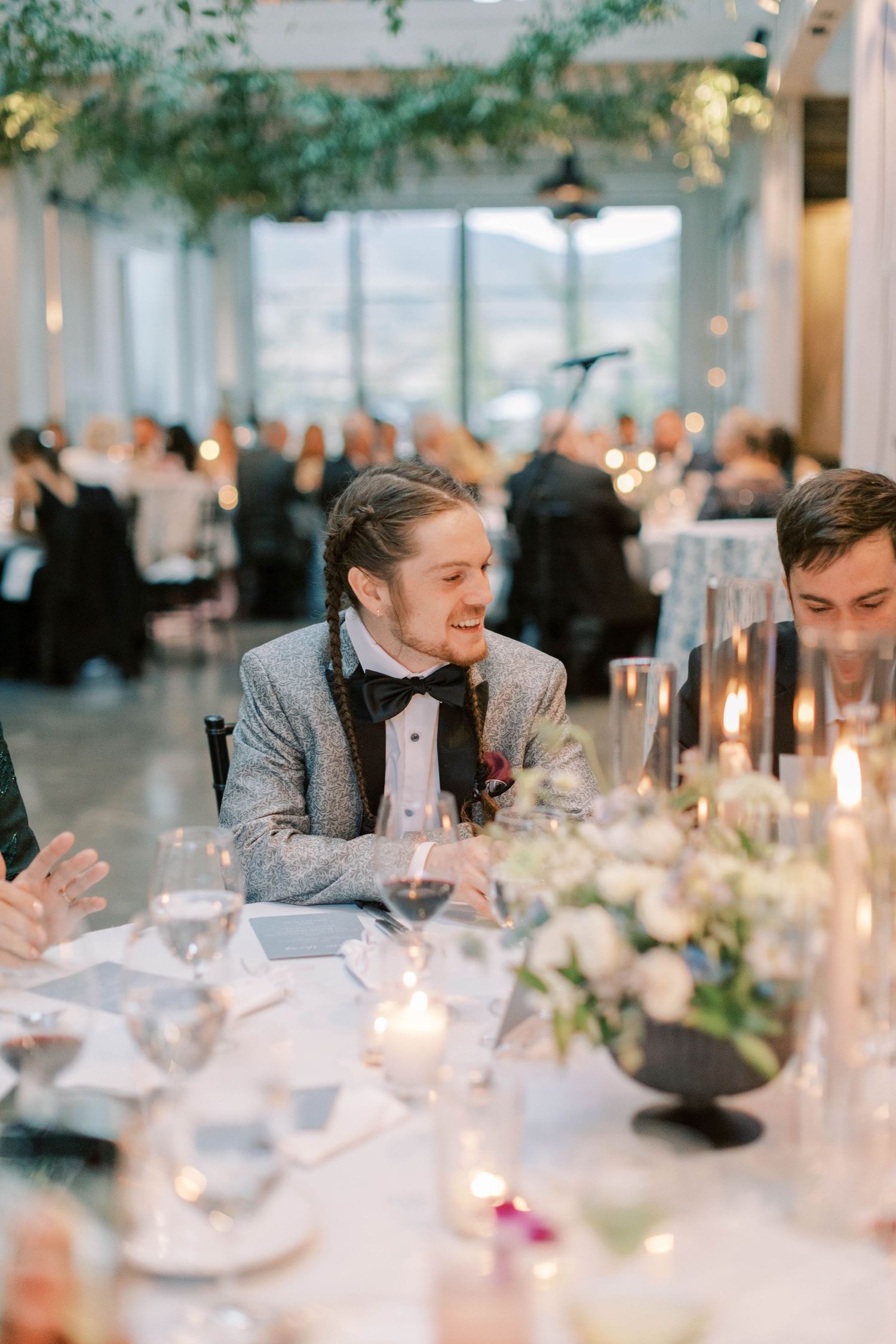 Candlelit wedding reception with guests dining at elegantly decorated tables.