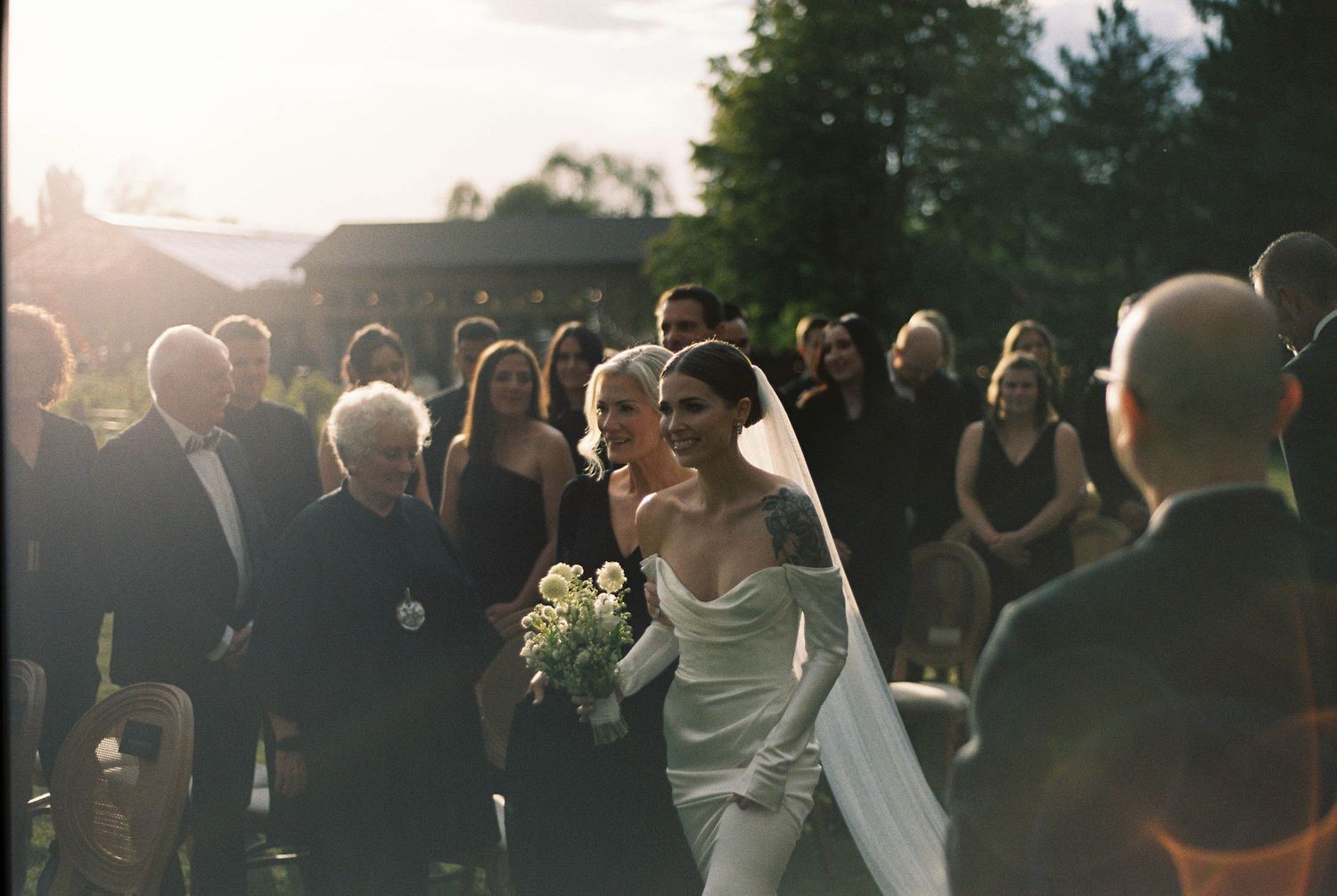 Wedding ceremony moment captured during golden hour with guests in attendance.