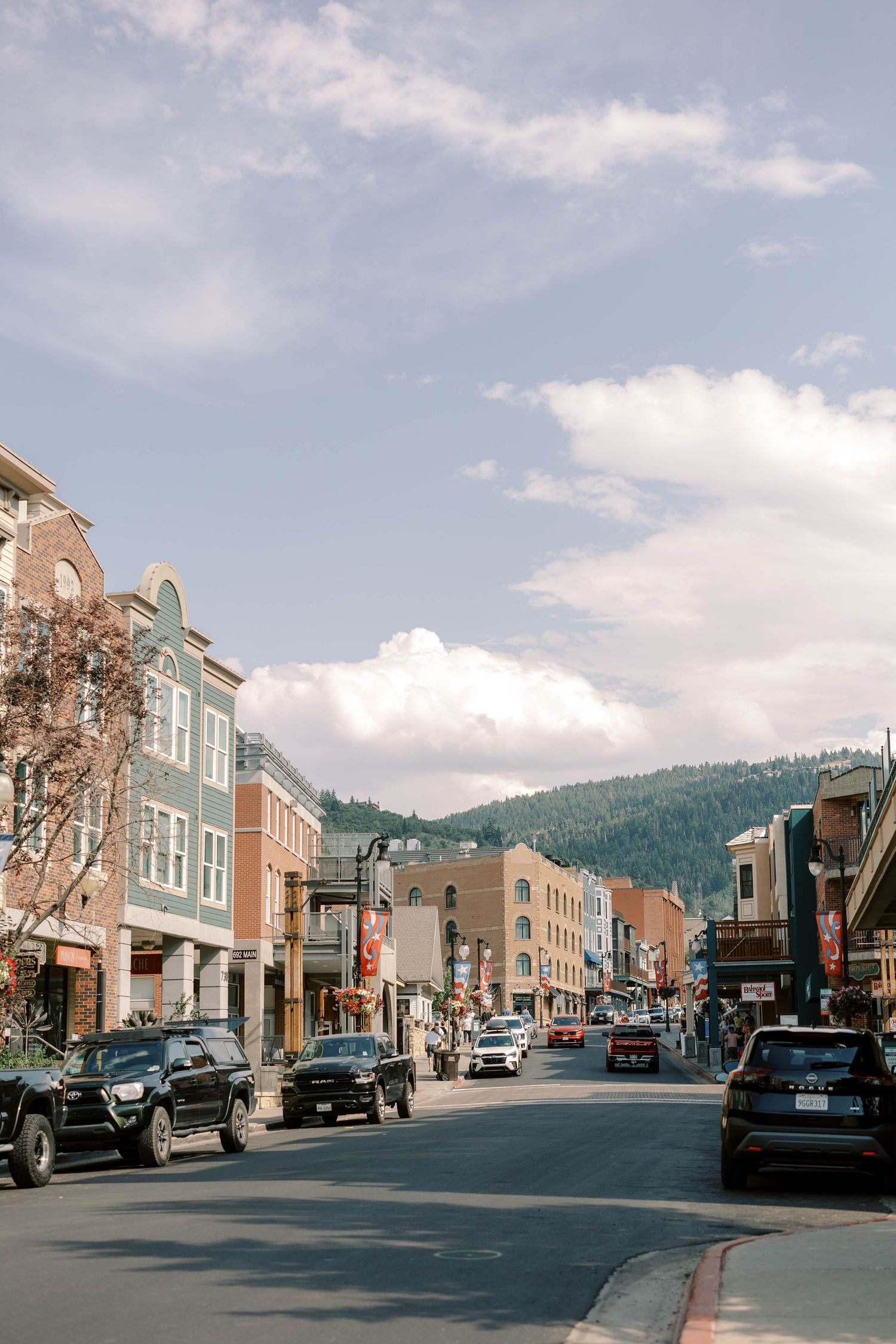 Charming mountain town main street of park city with colorful buildings and parked cars on sunny day.