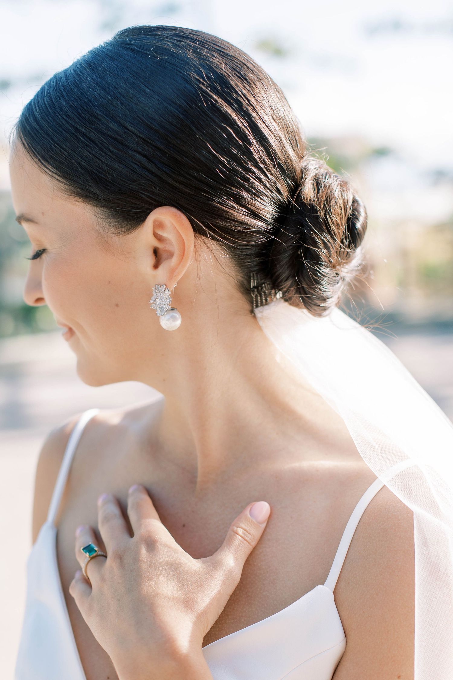 Close-up profile of bride wearing sparkly earring and elegant updo hairstyle.