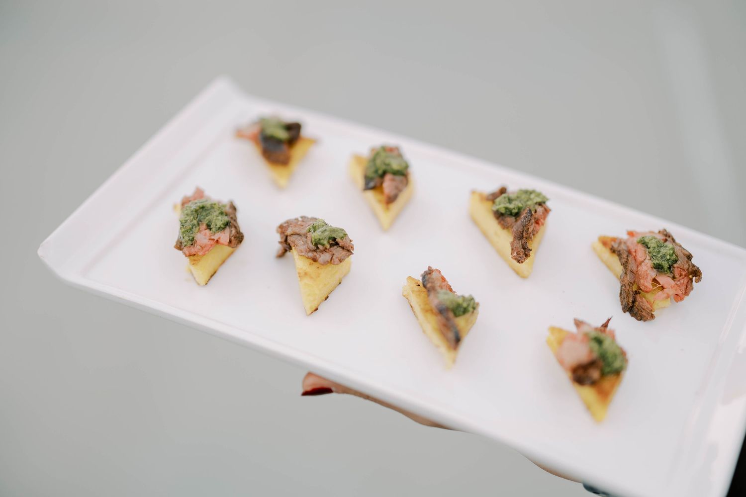 Elegant appetizers arranged on a white rectangular serving platter.