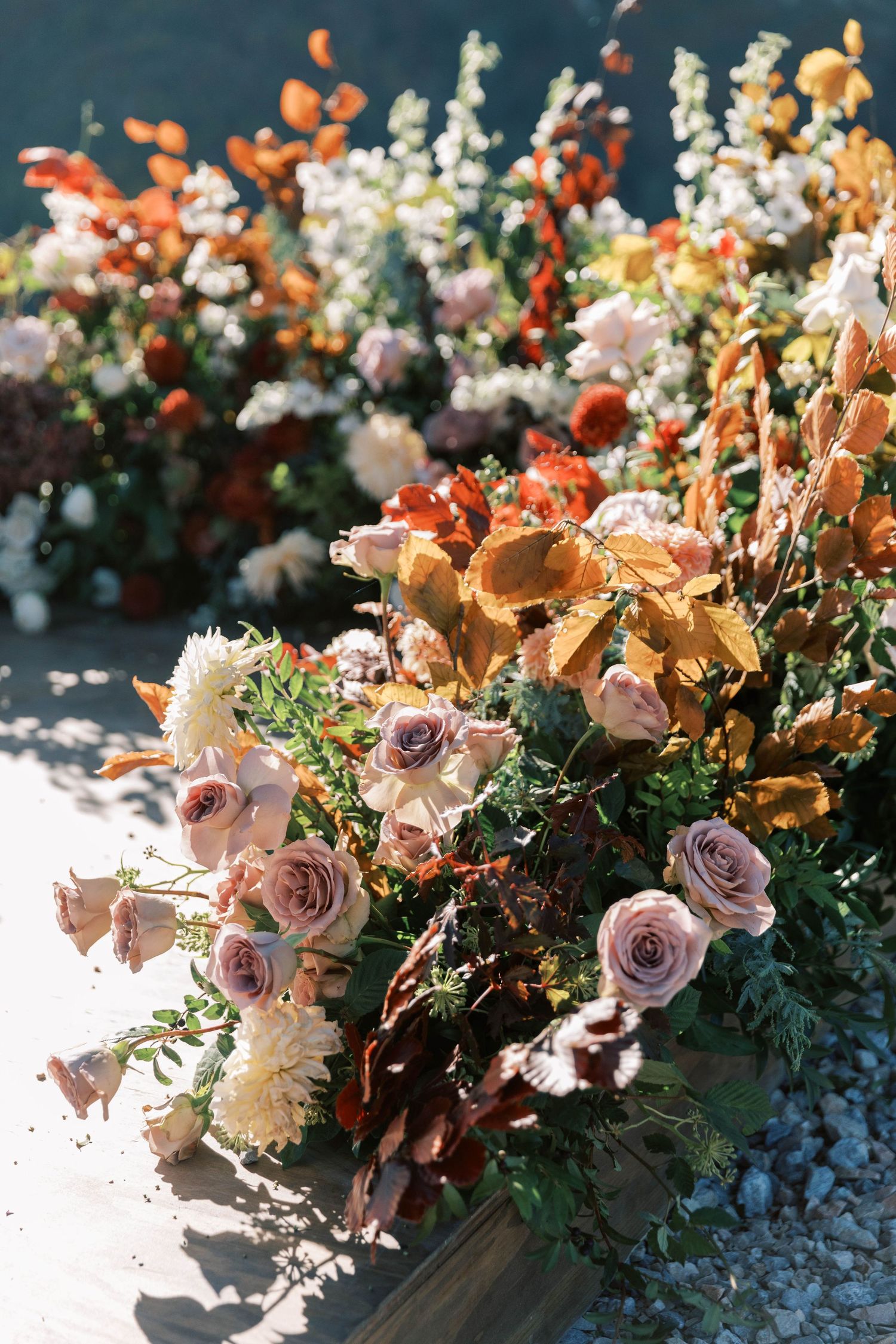 Lush floral arrangement with peach and coral roses mixed with white blooms and greenery.