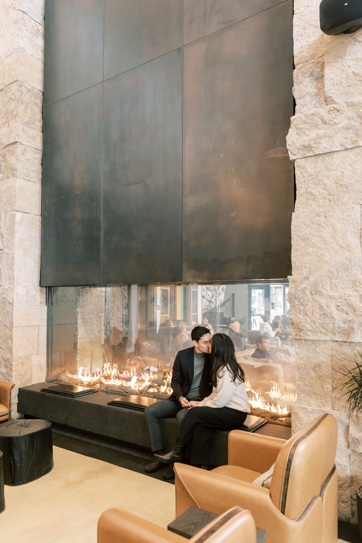 A romantic moment beside a modern fireplace with ambient lighting in an elegant interior setting at the pendry park city.