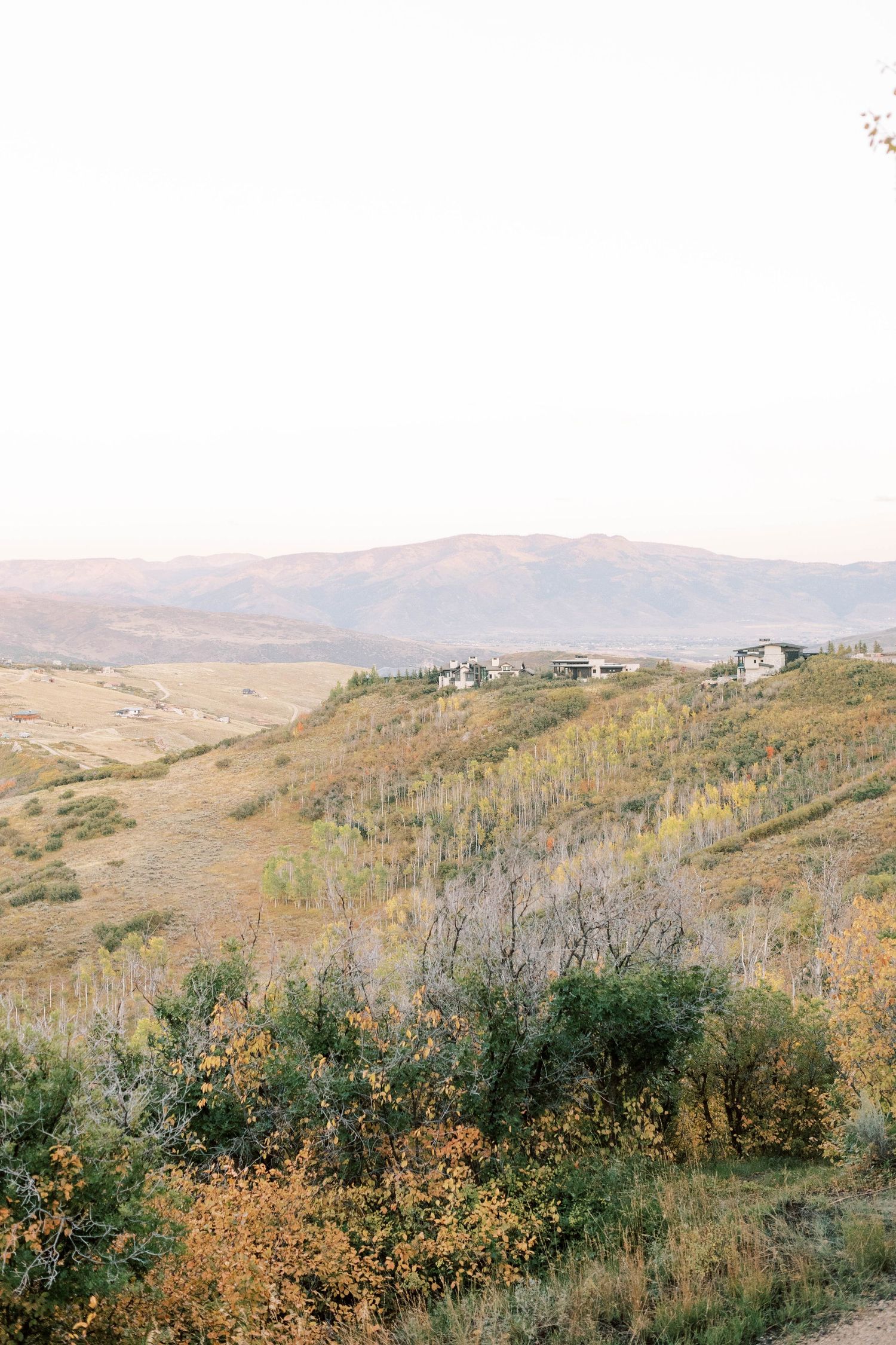Scenic mountain landscape with houses nestled on autumn hillside.