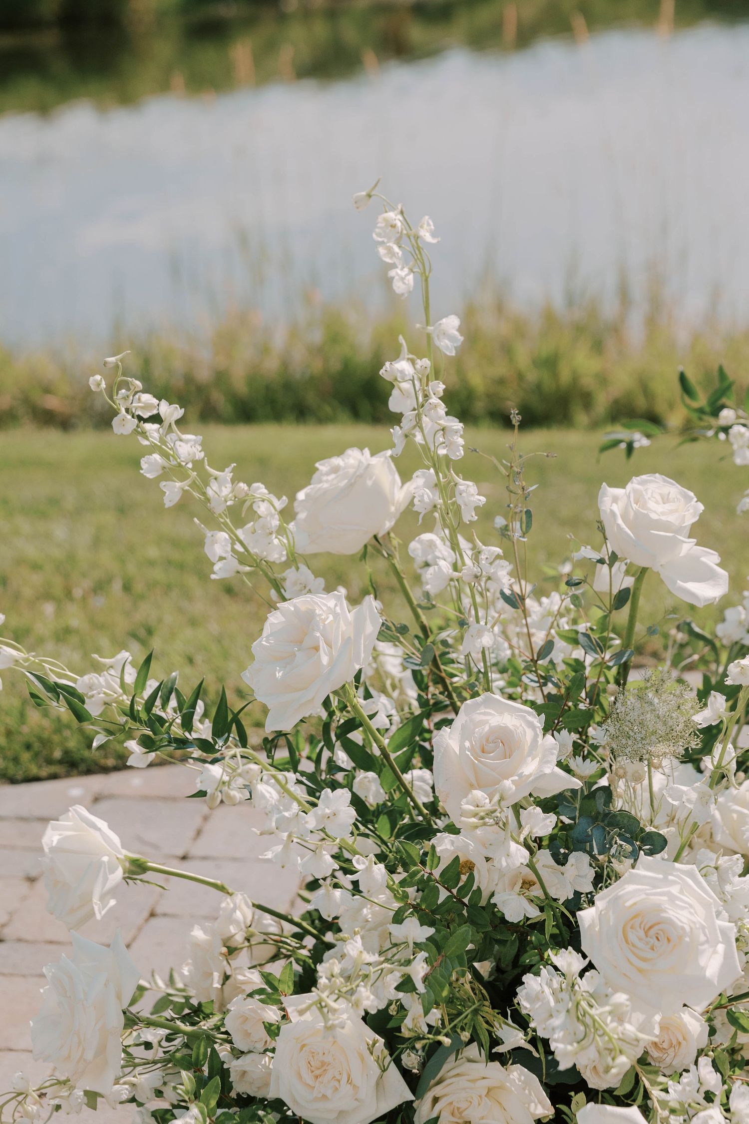 Elegant white rose and delphinium floral arrangement for wedding.