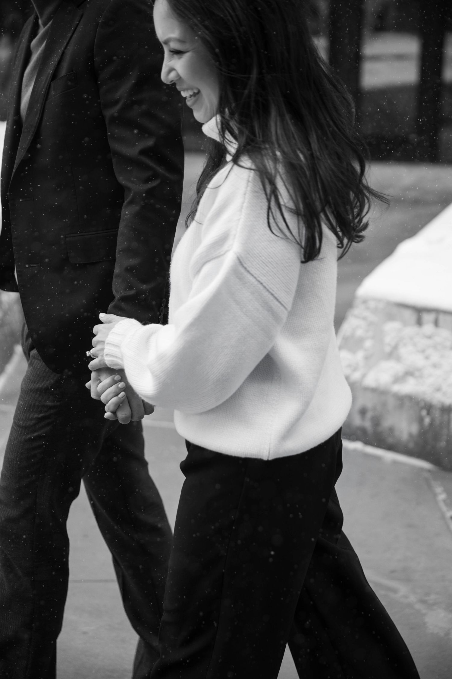 Black and white candid moment of couple walking together.