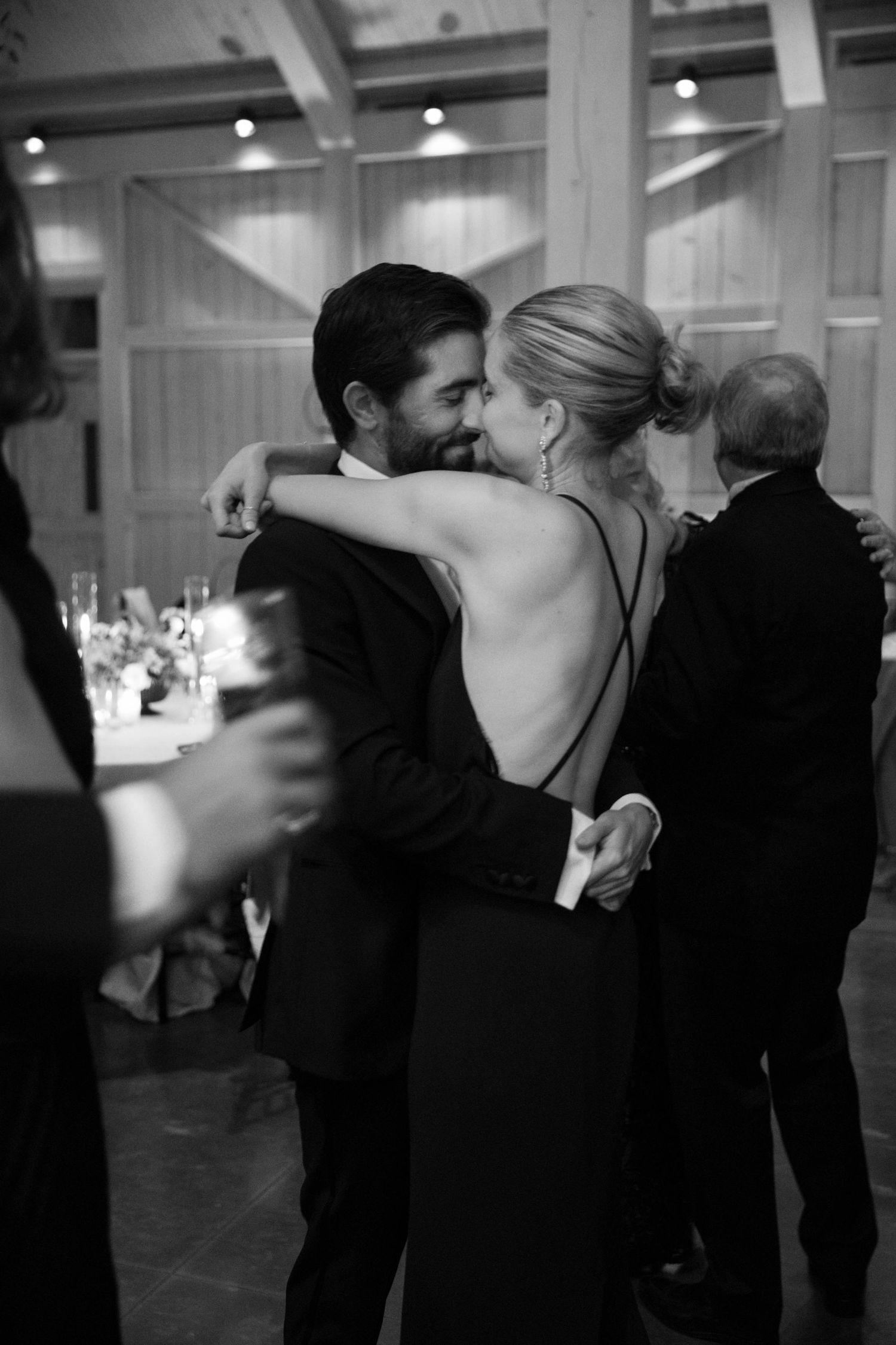 An intimate moment between guests during an elegant black tie wedding reception.