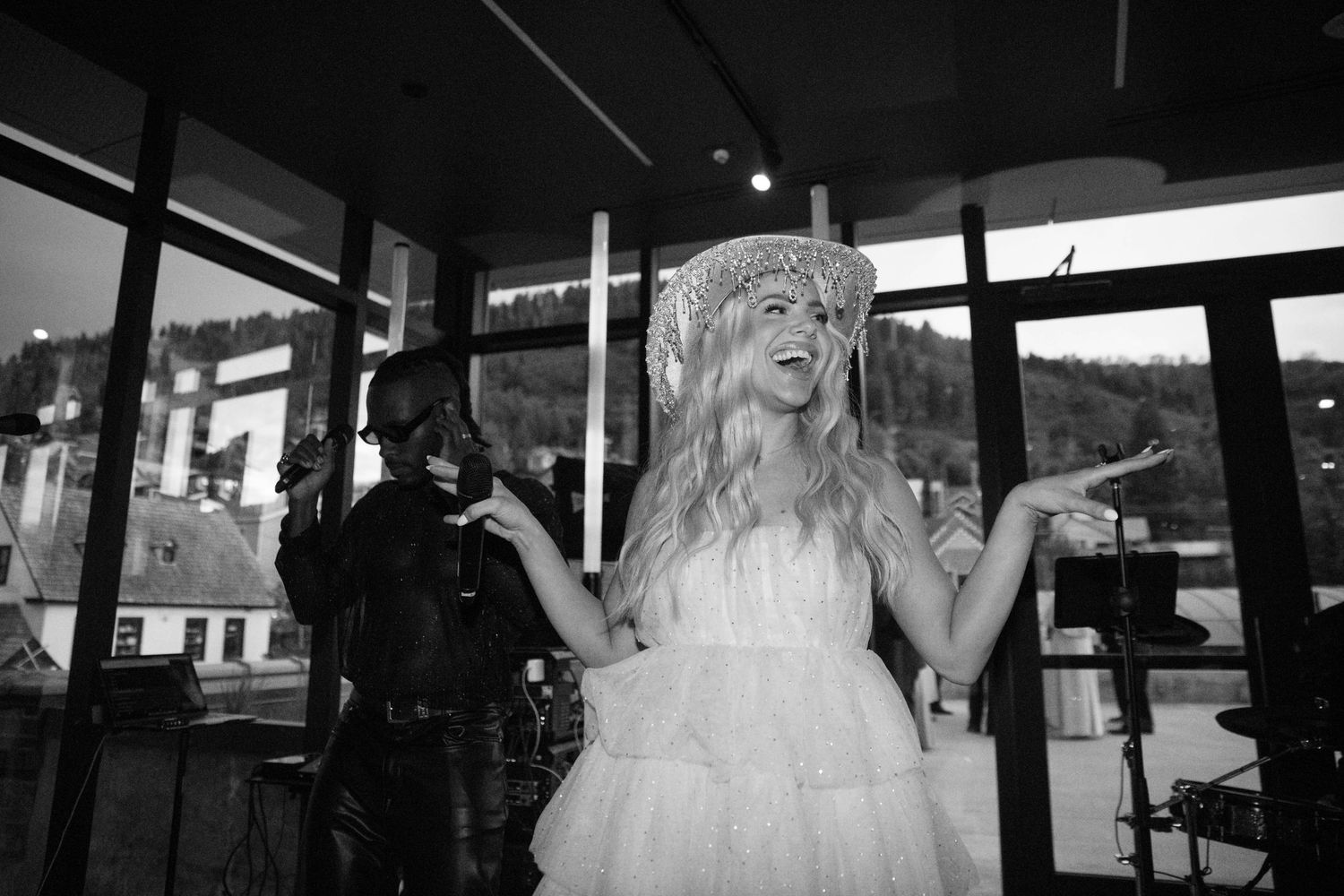 Bride in white dress dancing joyfully at indoor wedding reception venue.
