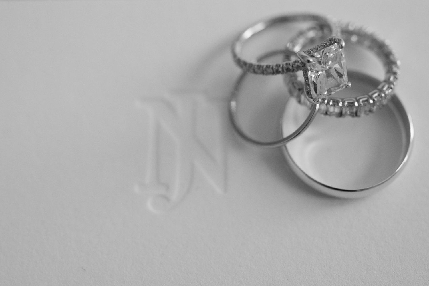 Three elegant diamond wedding rings arranged on light background.