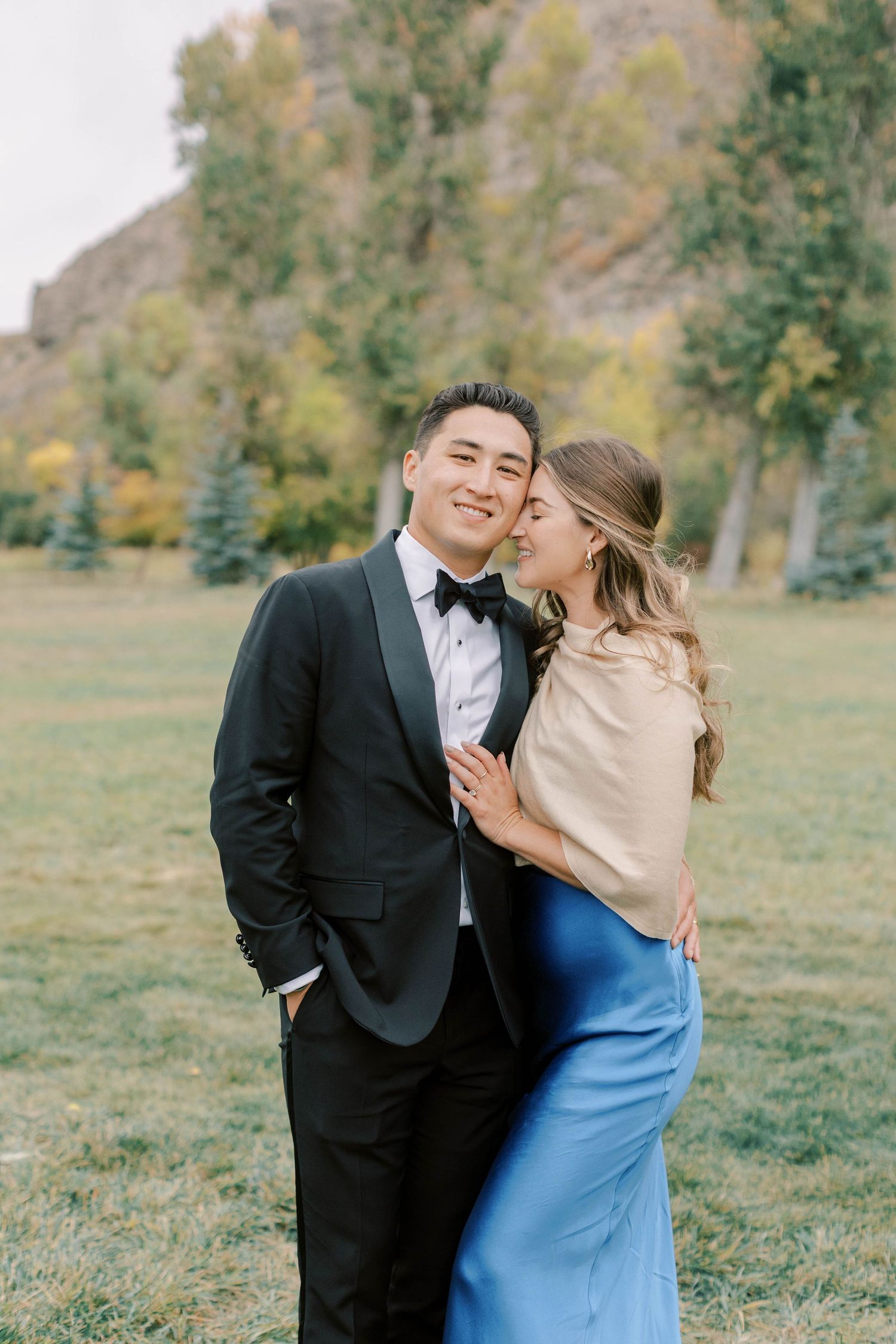 Elegant couple embracing during autumn outdoor photo session.