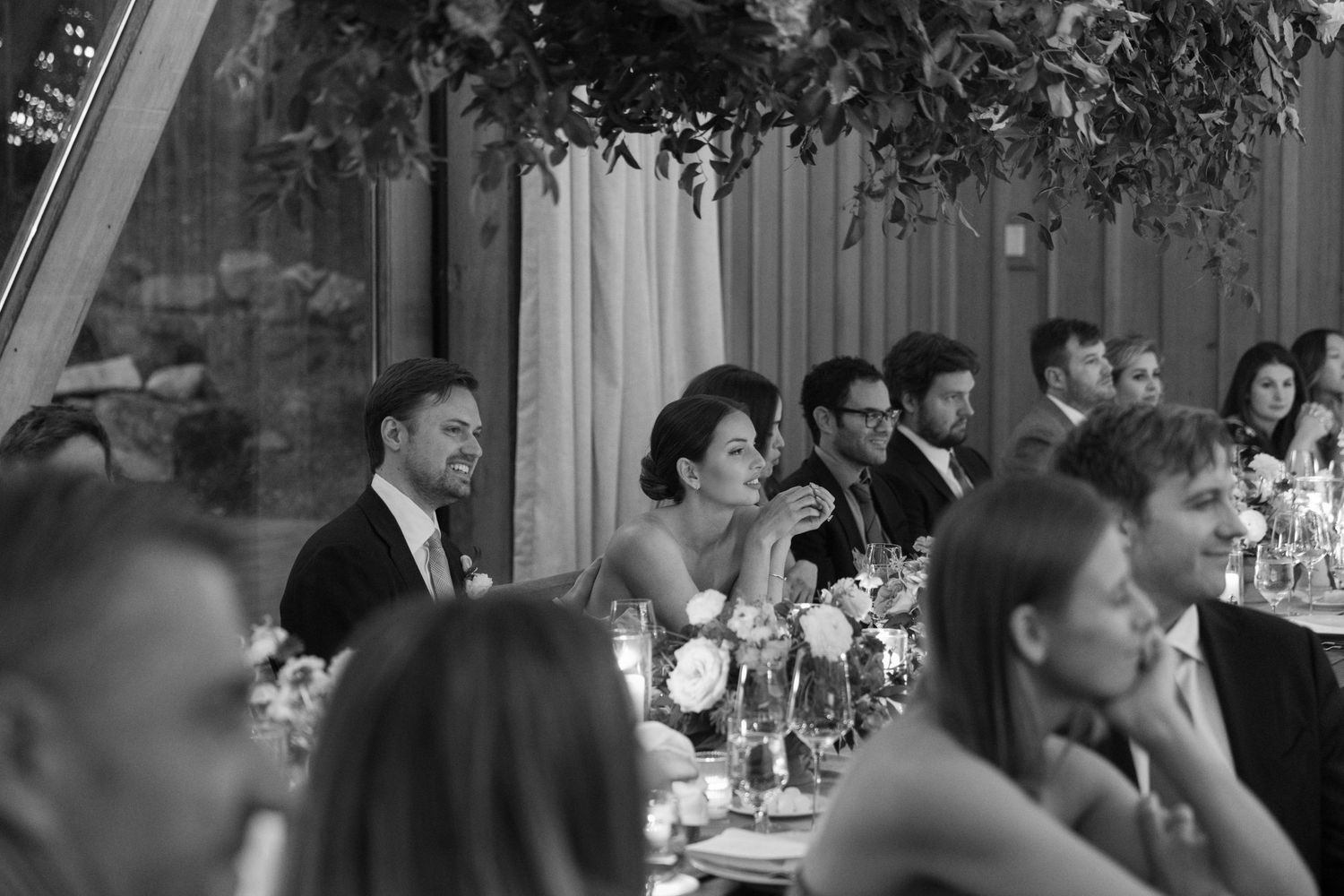 Candlelit reception dinner with guests seated at elegantly decorated tables under ambient lighting.
