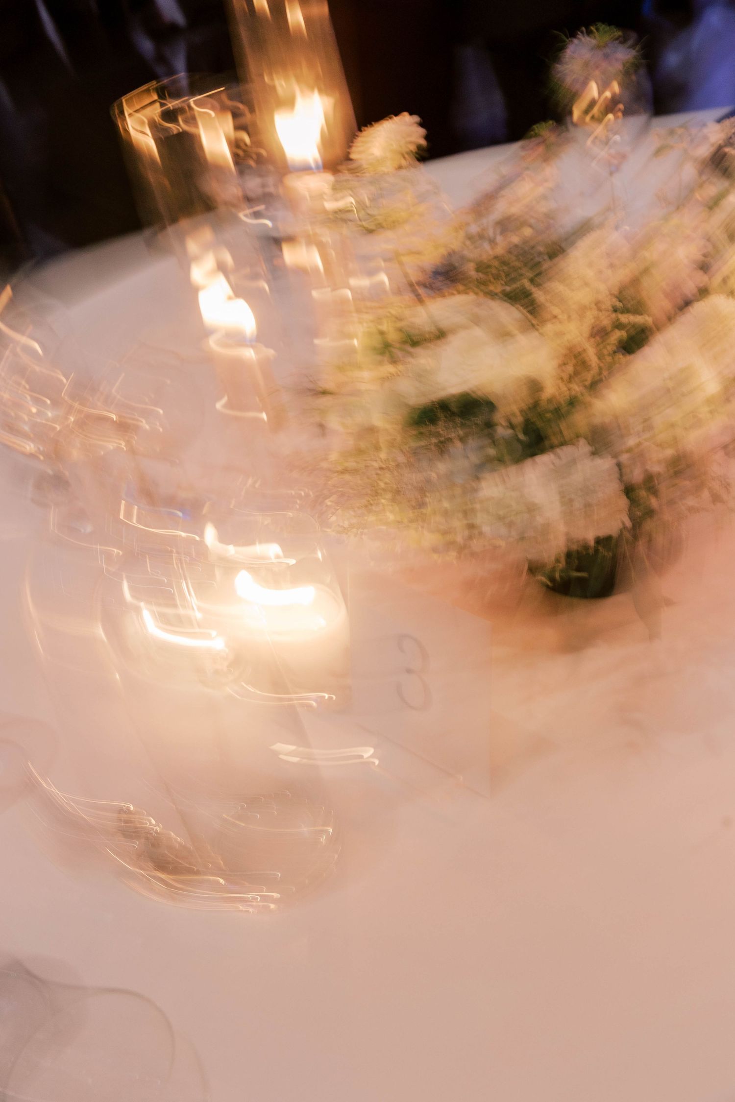 Abstract long exposure photo of wedding reception dancing capturing motion blur and candlelight.