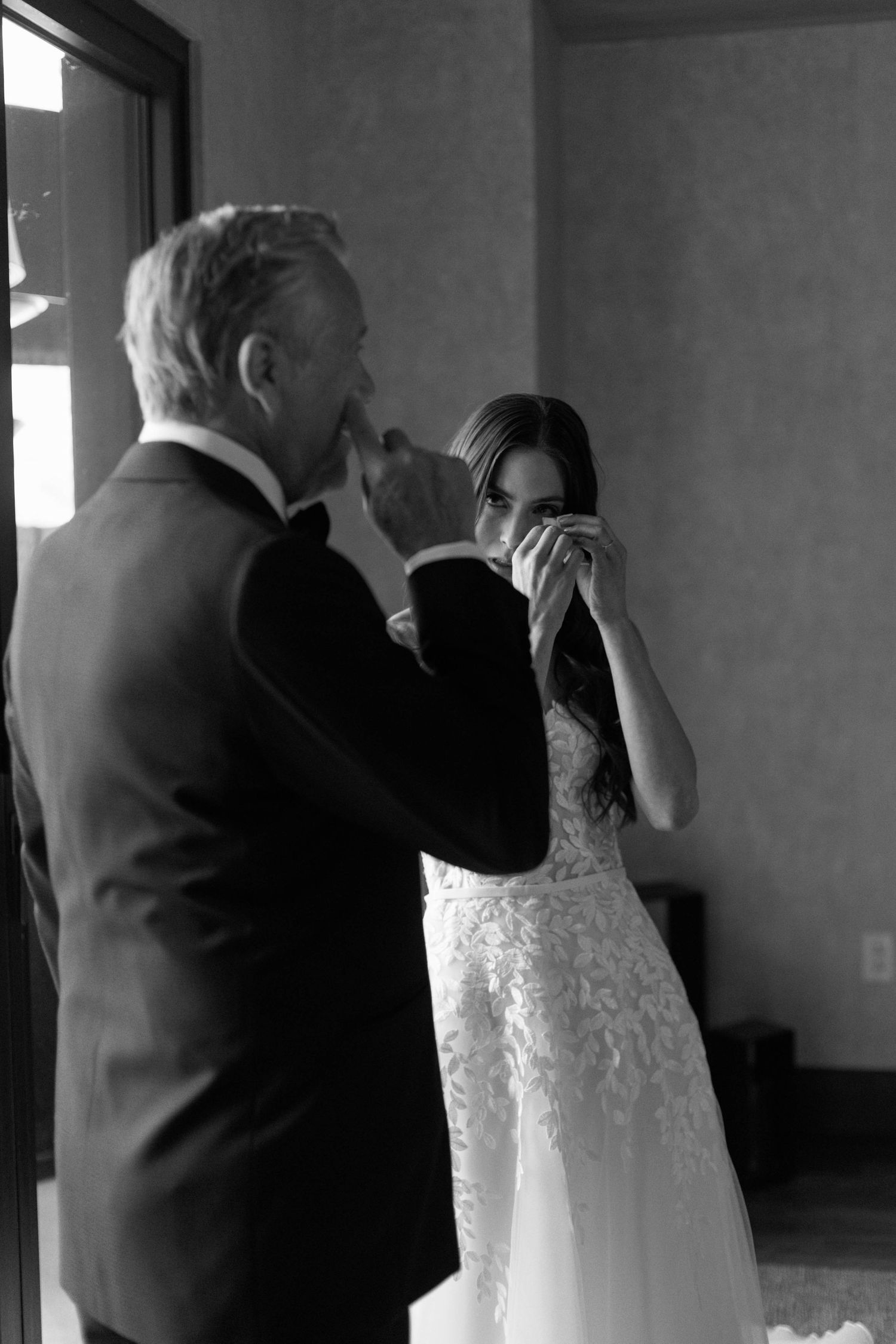 Black and white photo showing emotional reactions during a wedding first look.