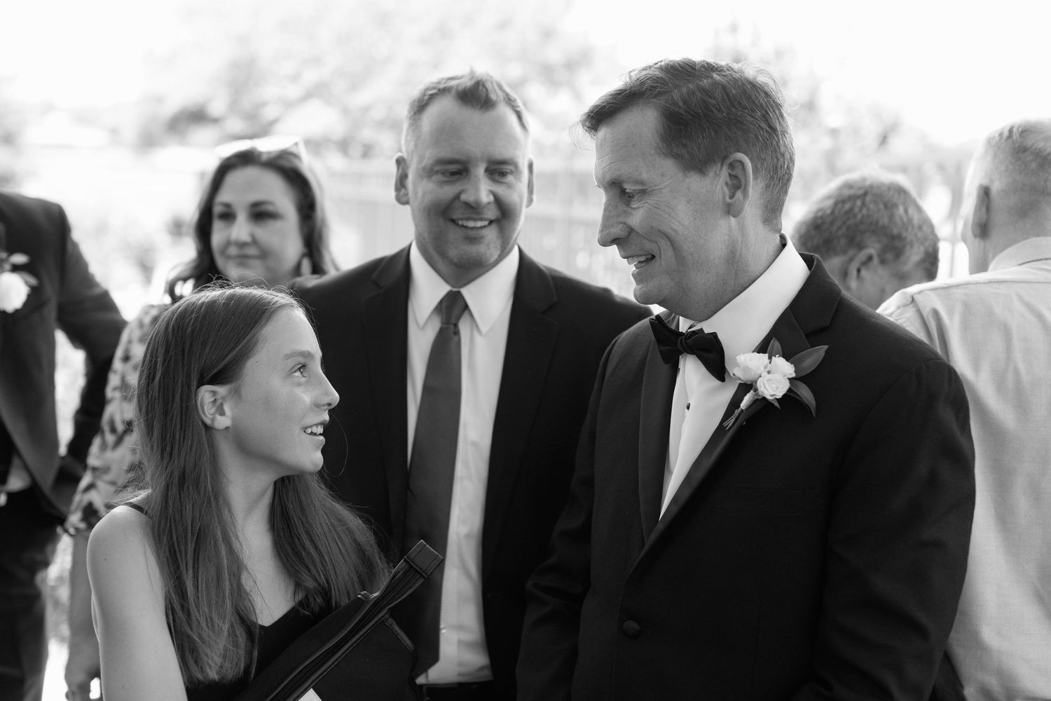Wedding guests share laughs and conversation during outdoor reception.