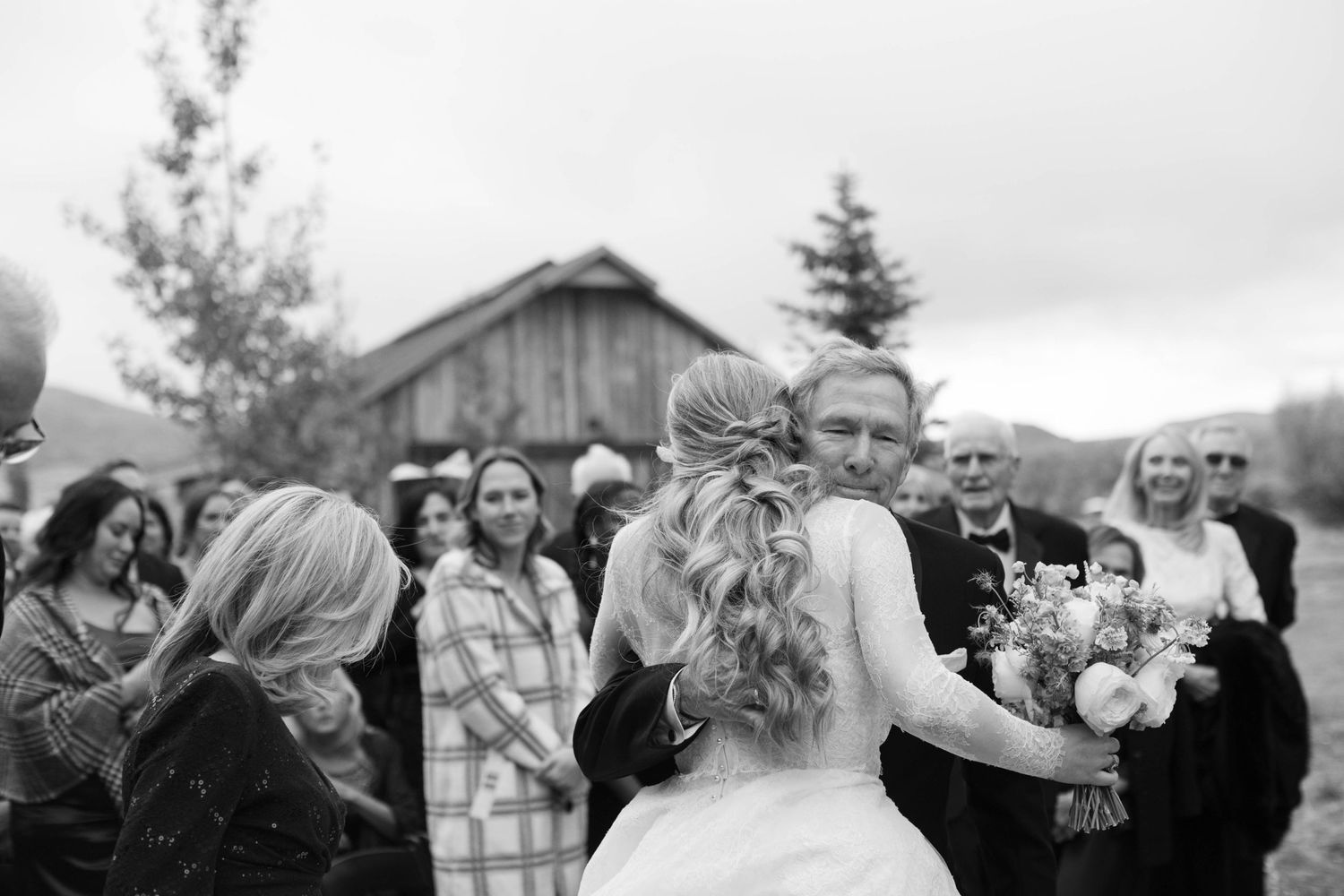 A celebratory moment outside a rustic barn during a wedding ceremony.