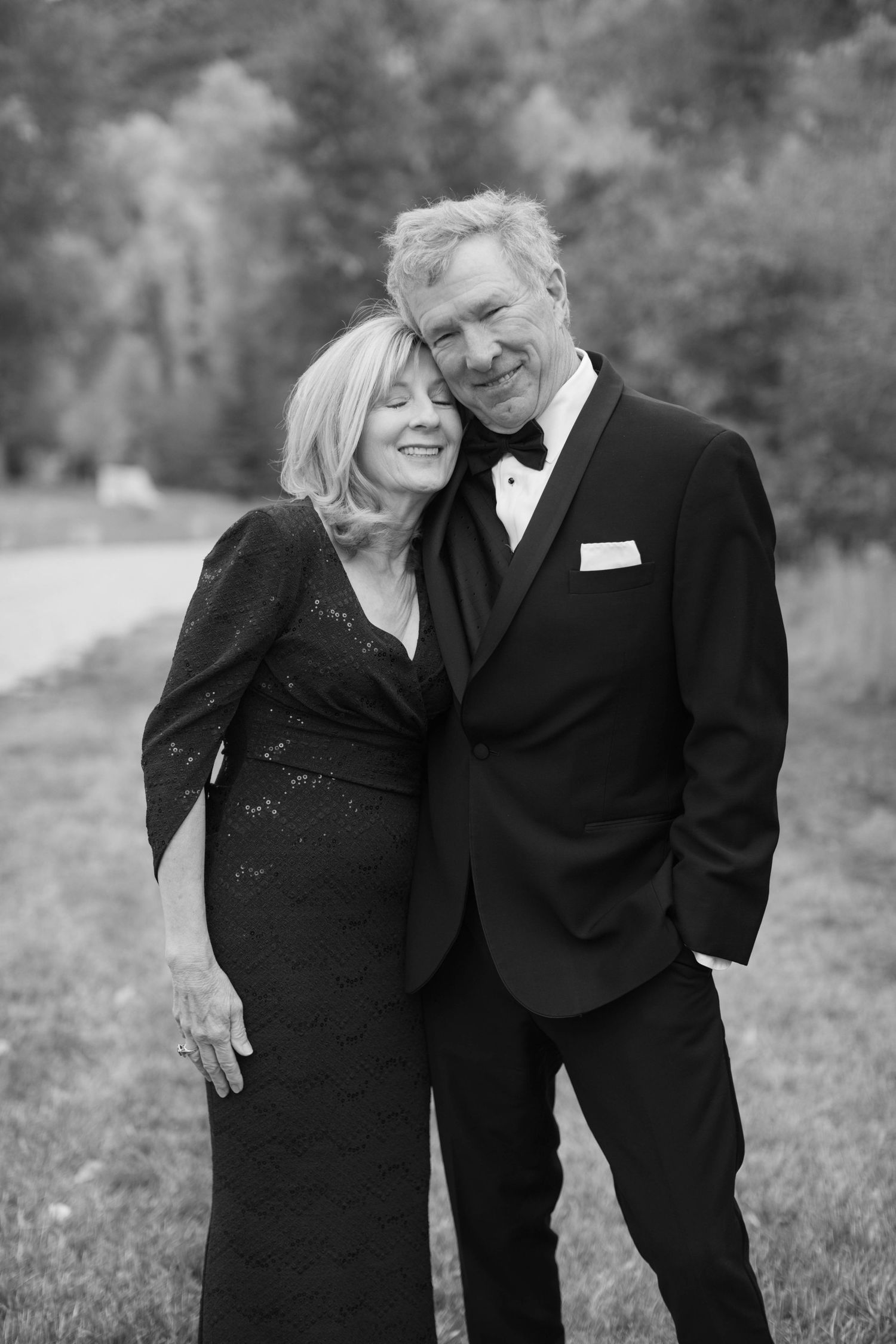 A couple embracing and laughing together at a formal event.