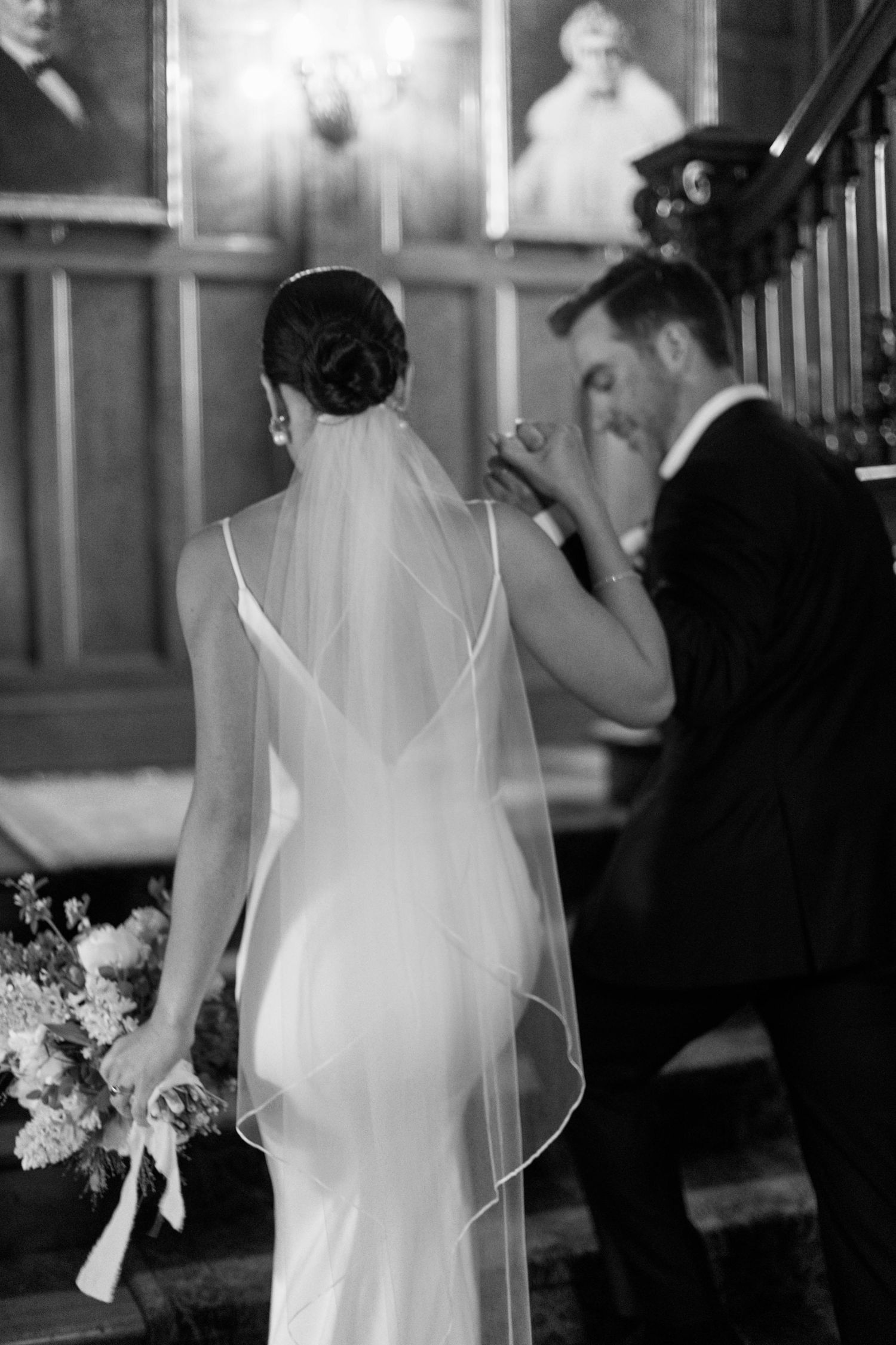 Black and white photo of couple by vintage portraits, bride wearing sleek gown with sheer veil.
