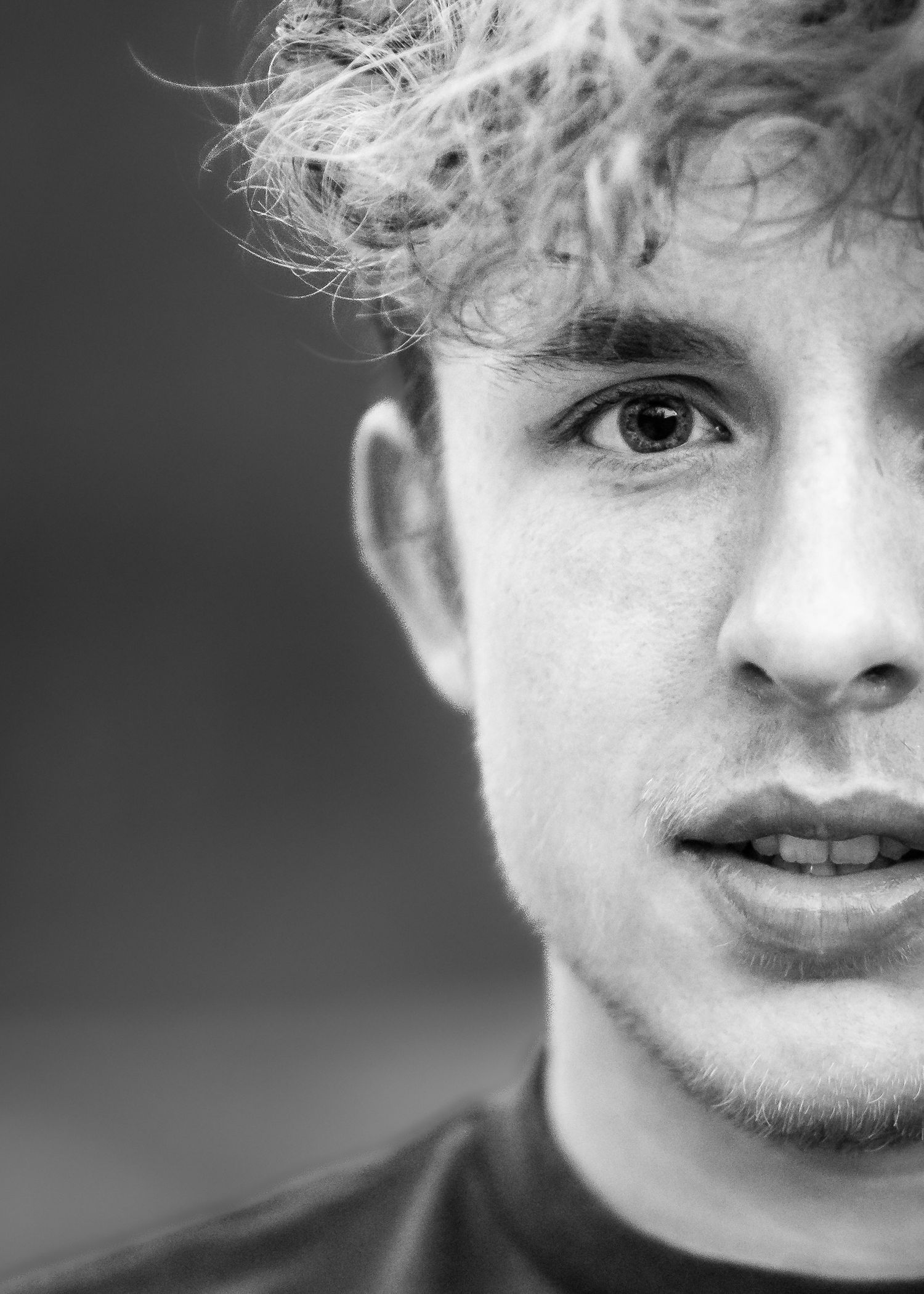 black and white extreme closeup senior portrait of a high school student with dark eyes and curly hair