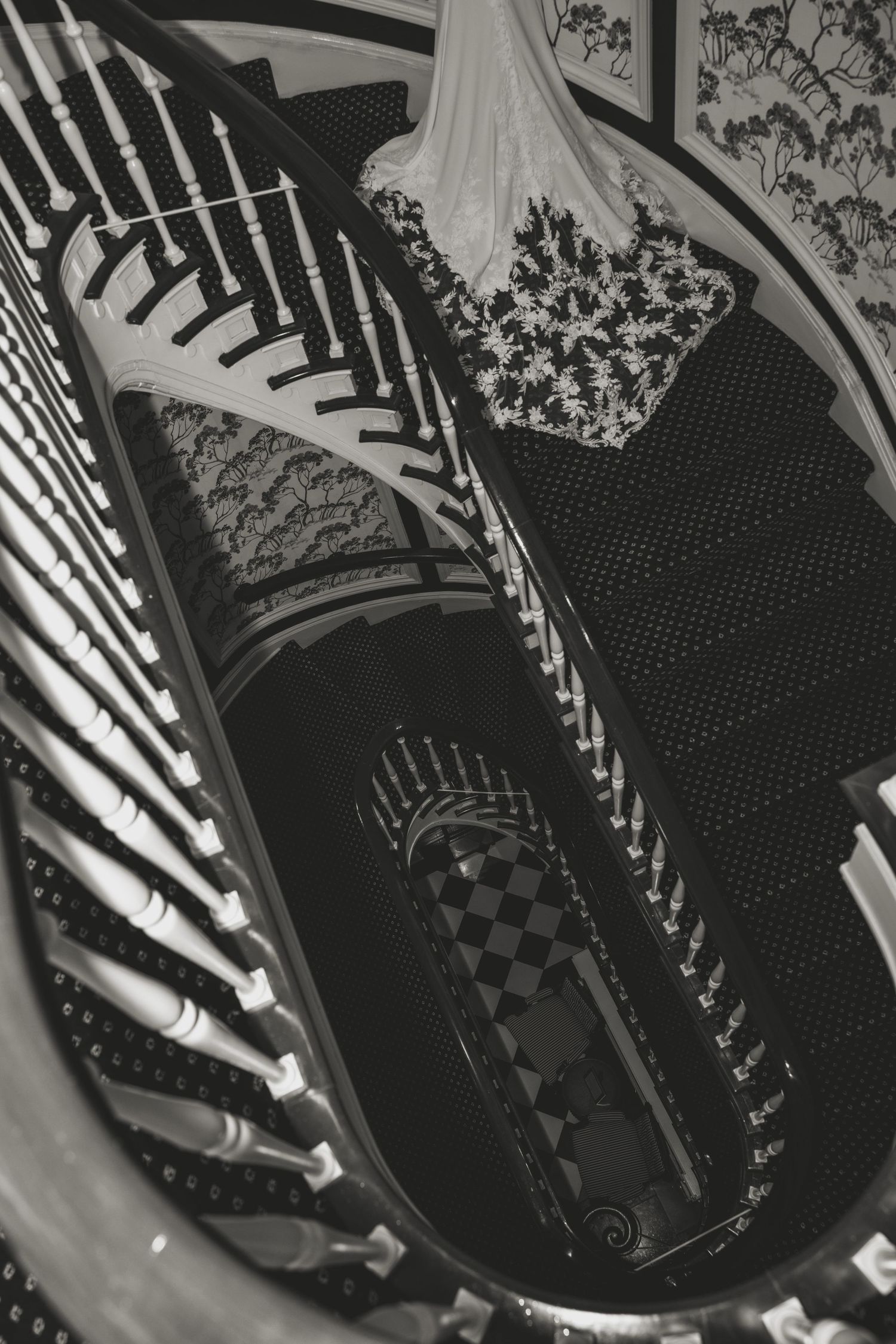 Black and white photograph showing a spiral staircase with polka dot carpeting viewed from above.