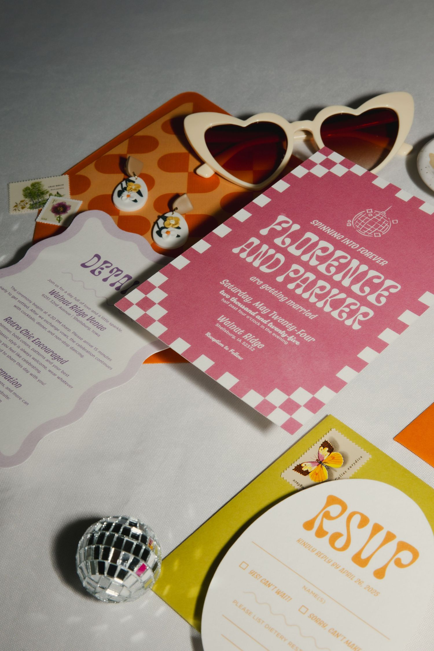 Retro styled party invitation with heart-shaped sunglasses, a mini disco ball, and pink and yellow RSVP cards on white surface.