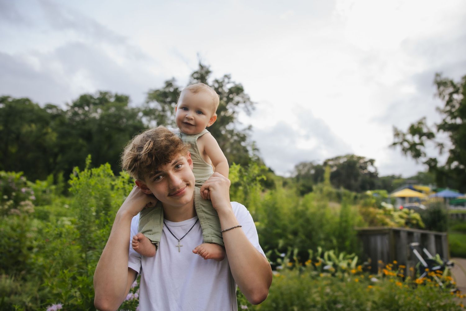 Happy family having fun playing and posing outdoors in greenery and wildflowers on a sunny afternoon.