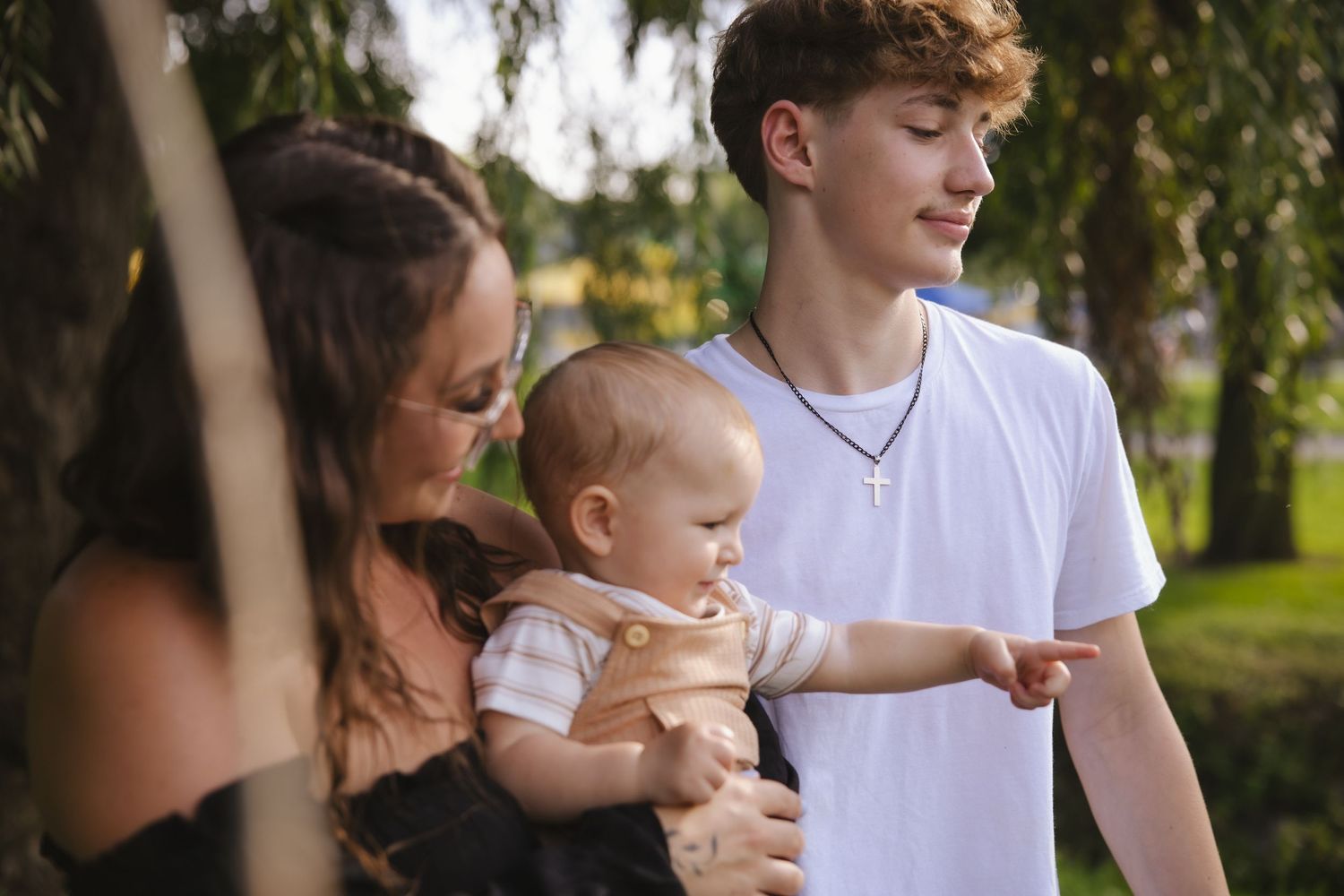 A parenting series shows tender bonding moments between adults and toddler in an outdoor park setting.