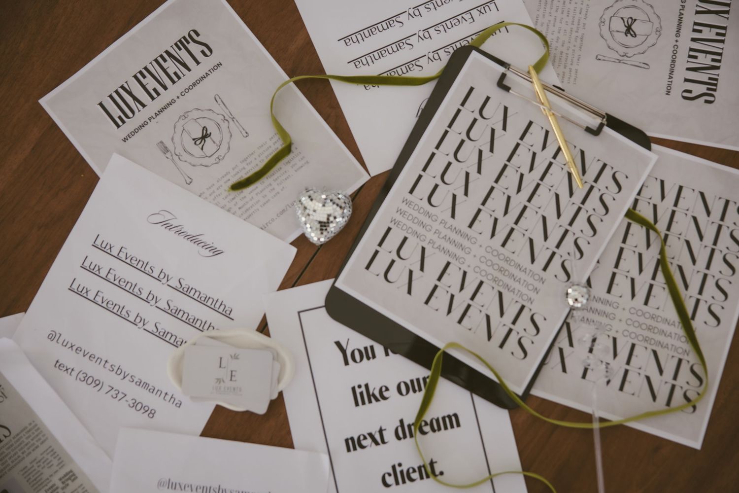 A collection of elegant white wedding invitations with calligraphy text laid out on wooden surfaces.