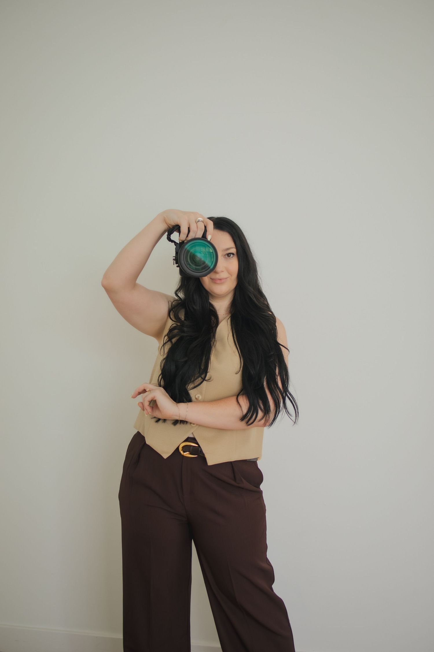 Person in brown wide-leg pants strikes dynamic poses against a neutral wall in a fashion photography series.