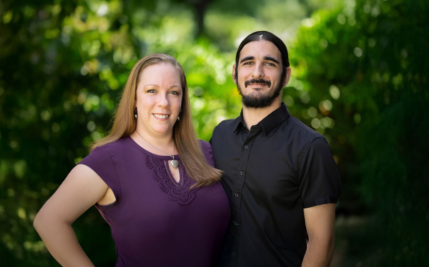 A couple poses together outdoors with greenery in the background on a sunny day. Tampa Photographer, Tampa Videographer, Florida Photography