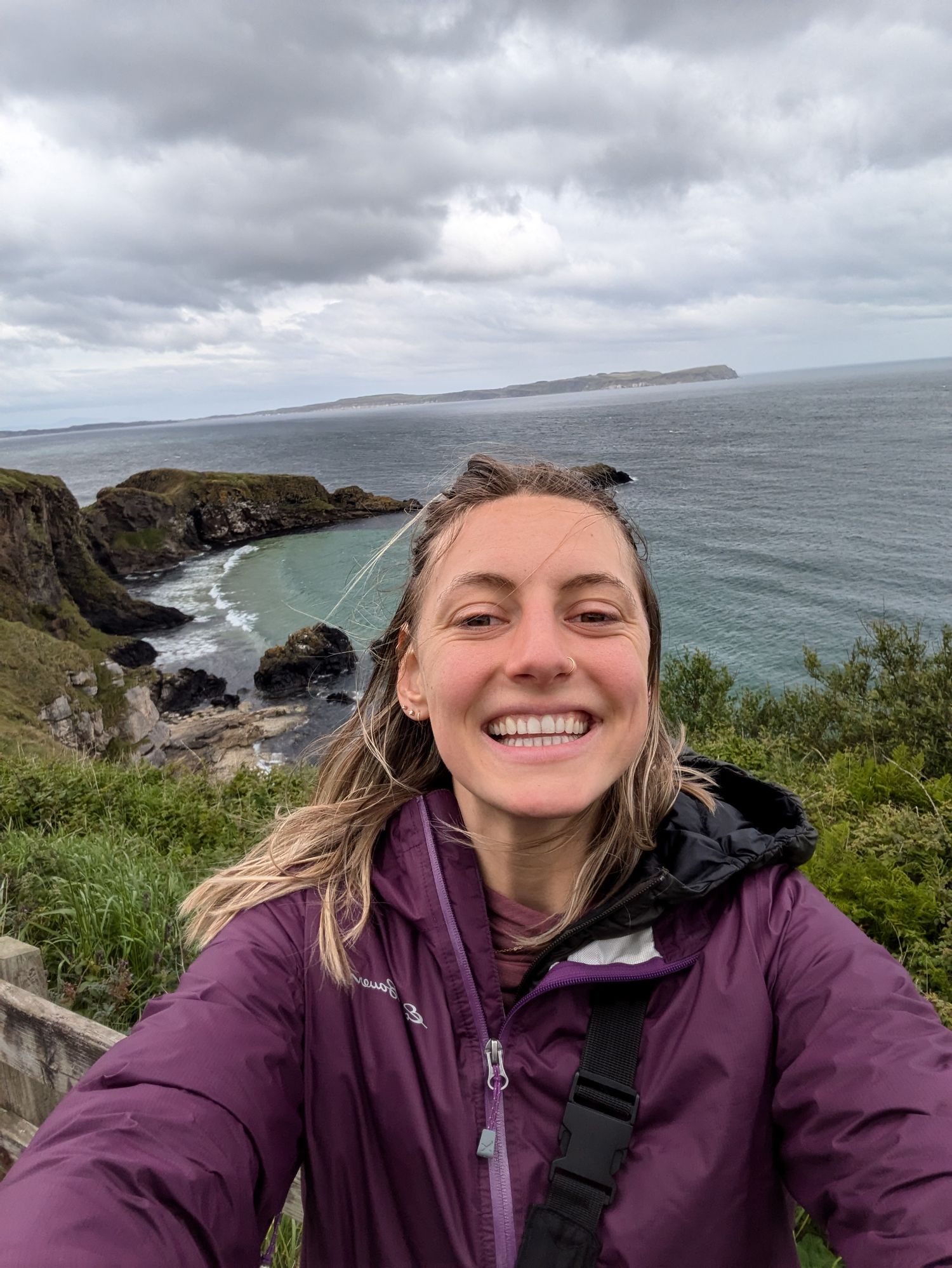A selfie captured along dramatic coastal cliffs with stormy skies and ocean views in Ireland.