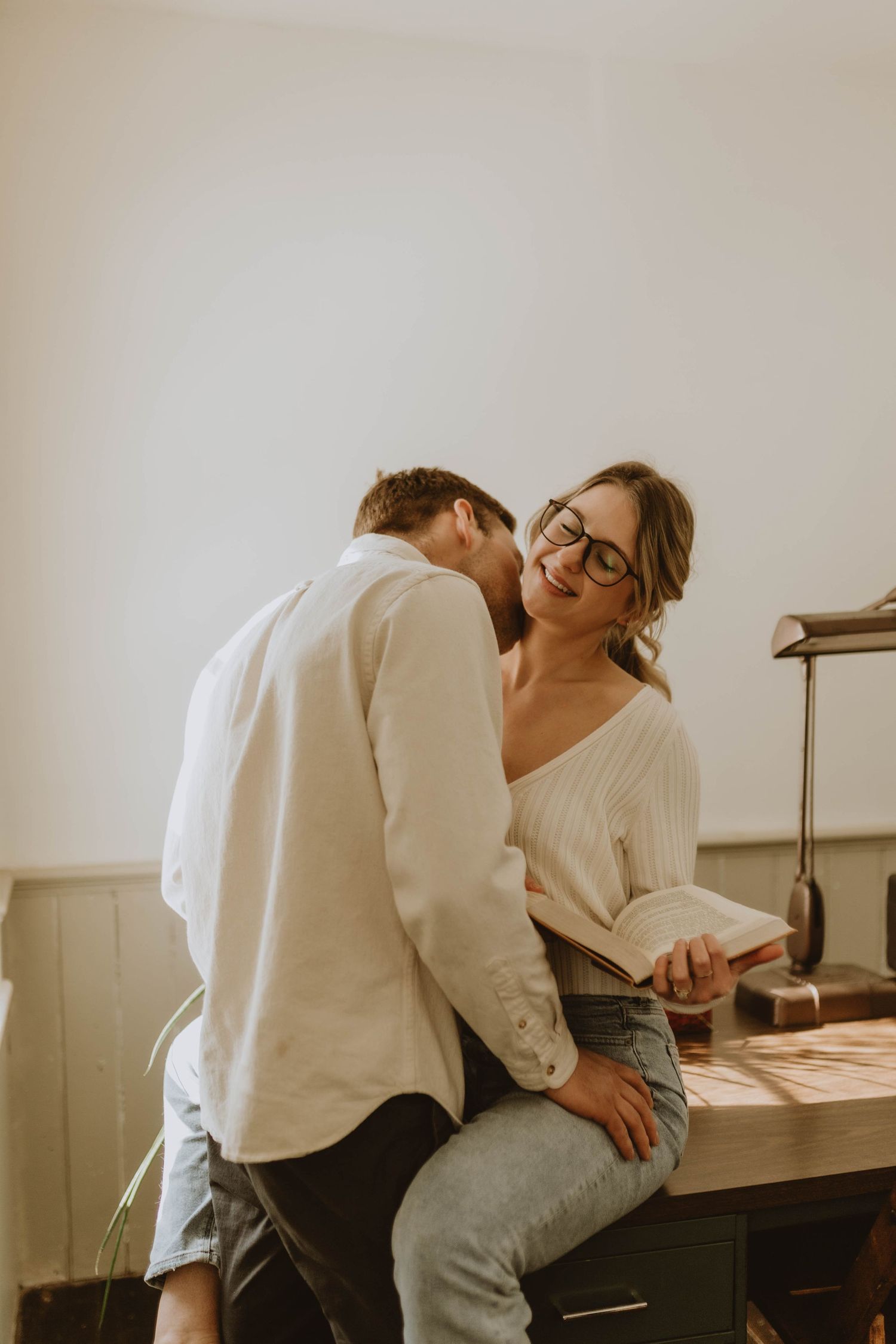 Couple sharing intimate moment in casual white outfits.
