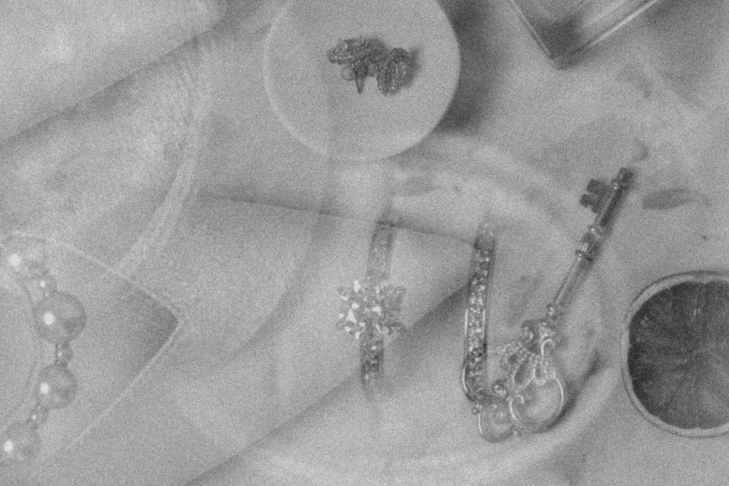 Close-up of vintage jewelry pieces and rings in black and white with soft focus.