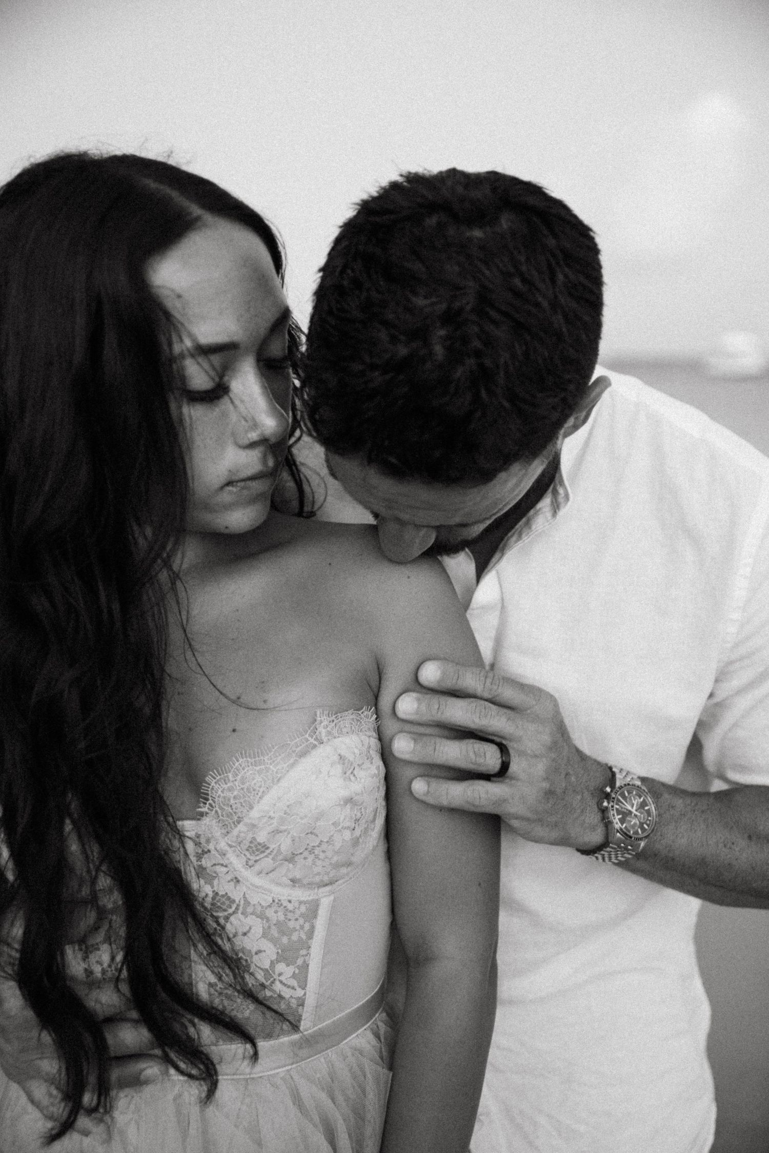 Intimate black and white portrait of couple in romantic embrace.