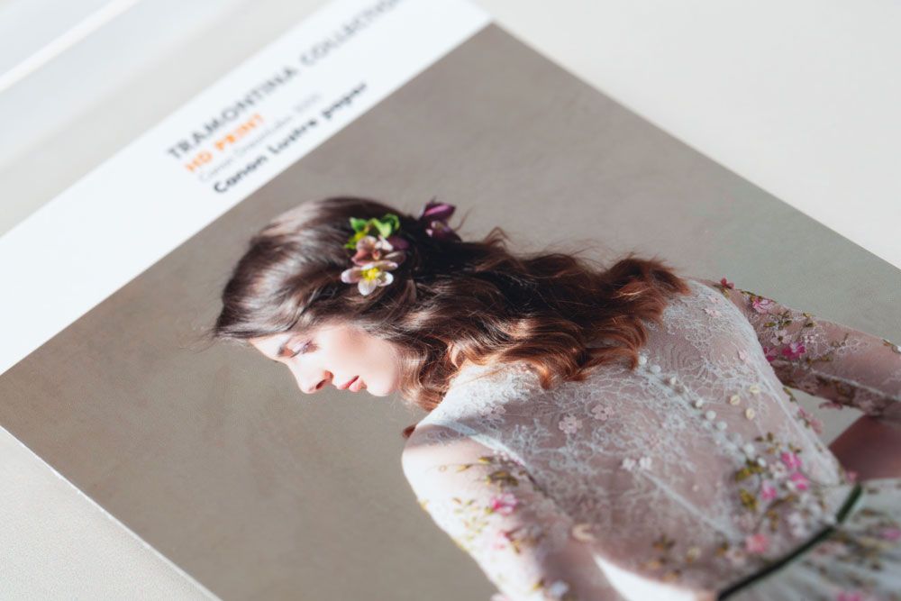 A vintage-style photo shows a feminine figure in a delicate lace dress with floral hairpiece from a gentle side angle.