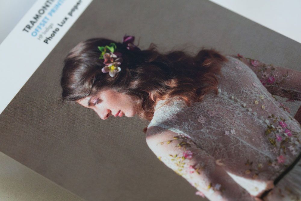 A delicate floral dress and flowers adorned in hair are captured in a dreamy vintage-style photograph.