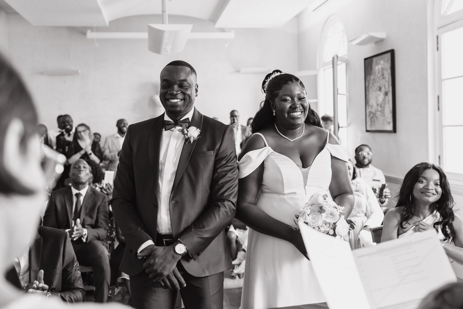 Wedding couple smiling and celebrating during joyful moment at ceremony.