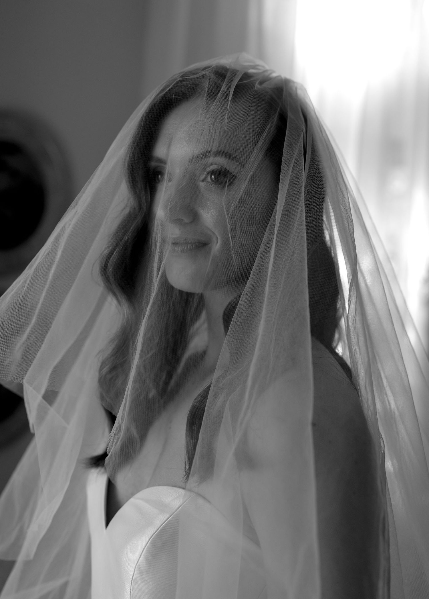 Ethereal bridal portrait with soft lighting and flowing veil creating a dreamy atmosphere.