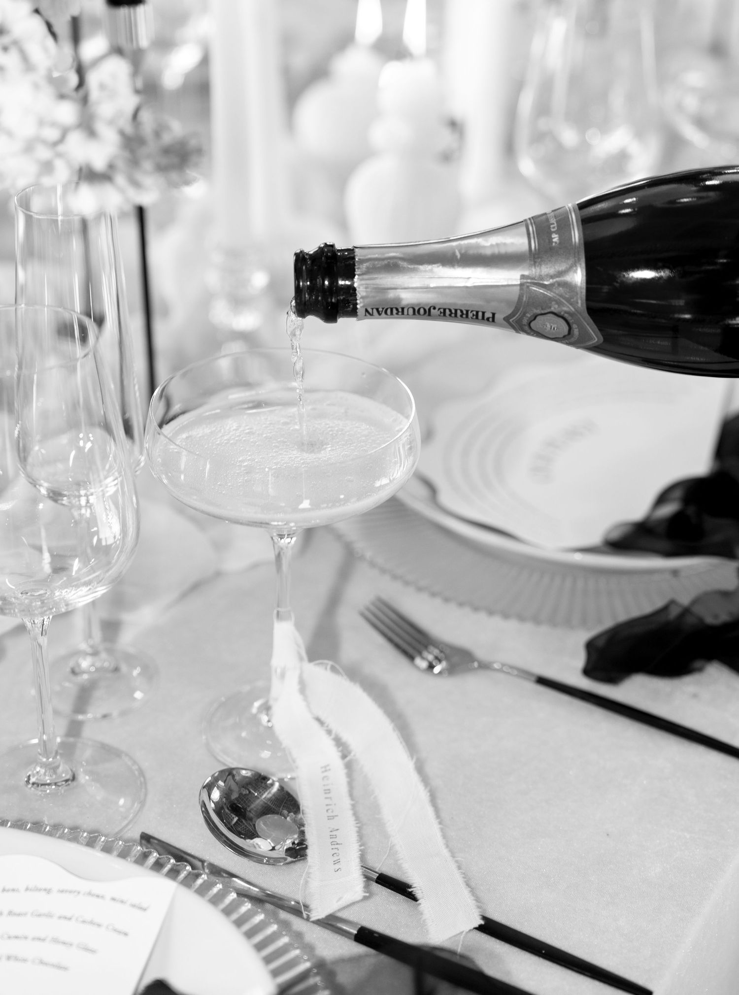 Champagne being poured into a coupe glass at an elegant wedding table setting in Franschhoek, La Roche Estate.