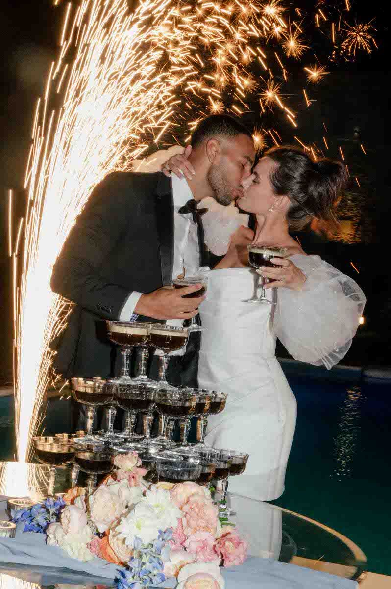 Champagne tower celebration with sparklers creating dramatic lighting effects.
