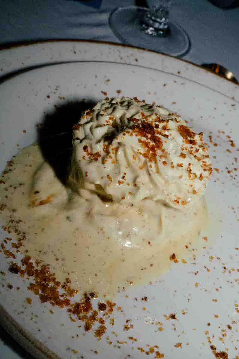 Creamy dessert topped with crumble and served on white plate.