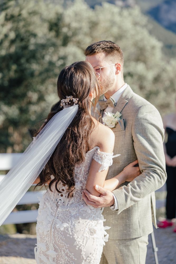 Romantic wedding moment captured as couple shares intimate embrace outdoors.