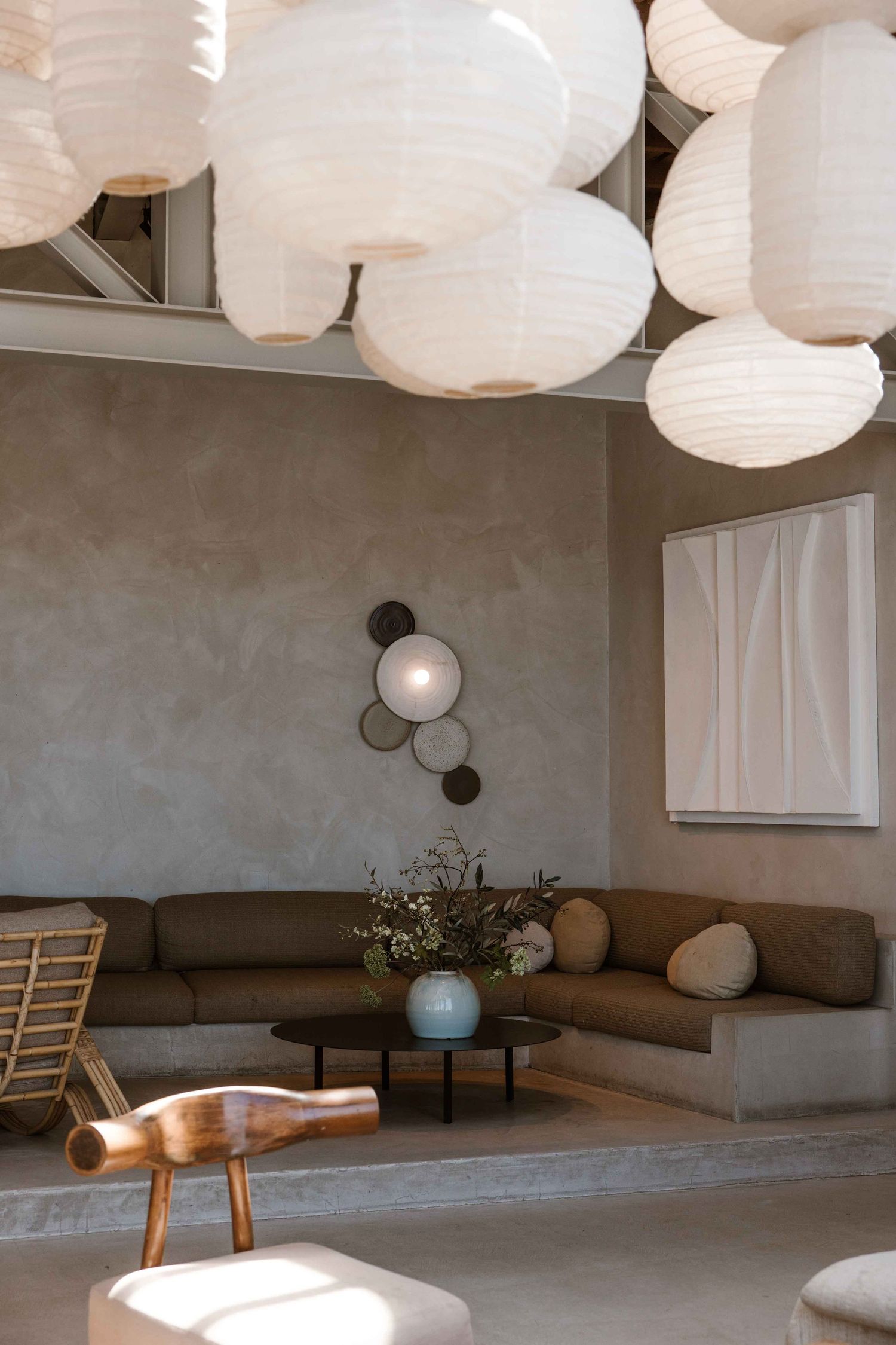 Modern living room with white paper lanterns and gray sectional sofa featuring minimalist wall sconces.